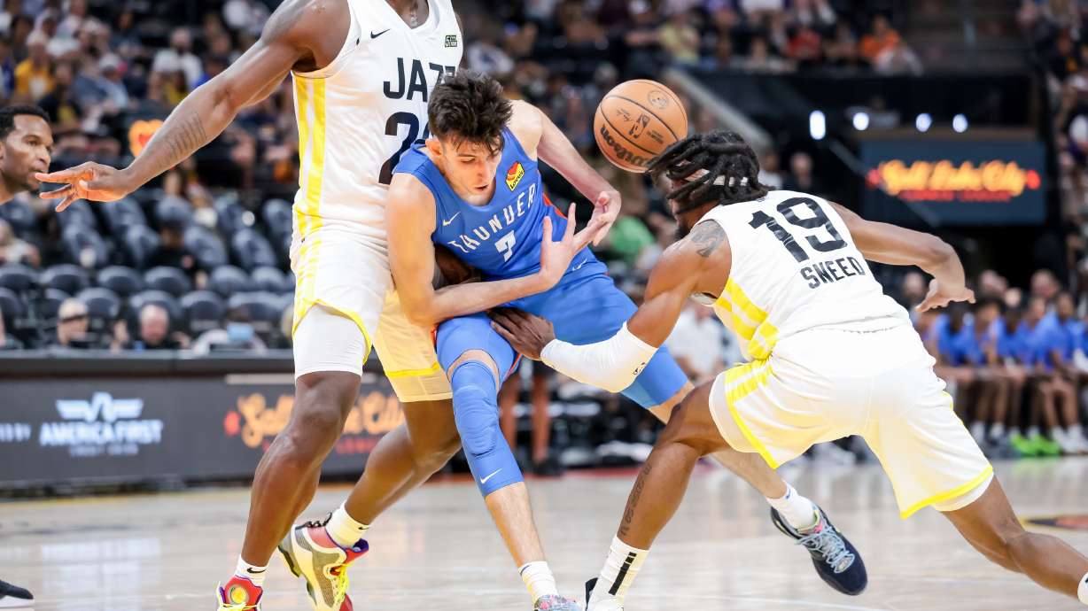 Chet Holmgren of the Oklahoma City Thunder loses the ball as Kofi Cockburn and Xavier Sneed of the Utah Jazz jam him up during a Summer League game at Vivint Arena in Salt Lake City on Tuesday, July 5, 2022.