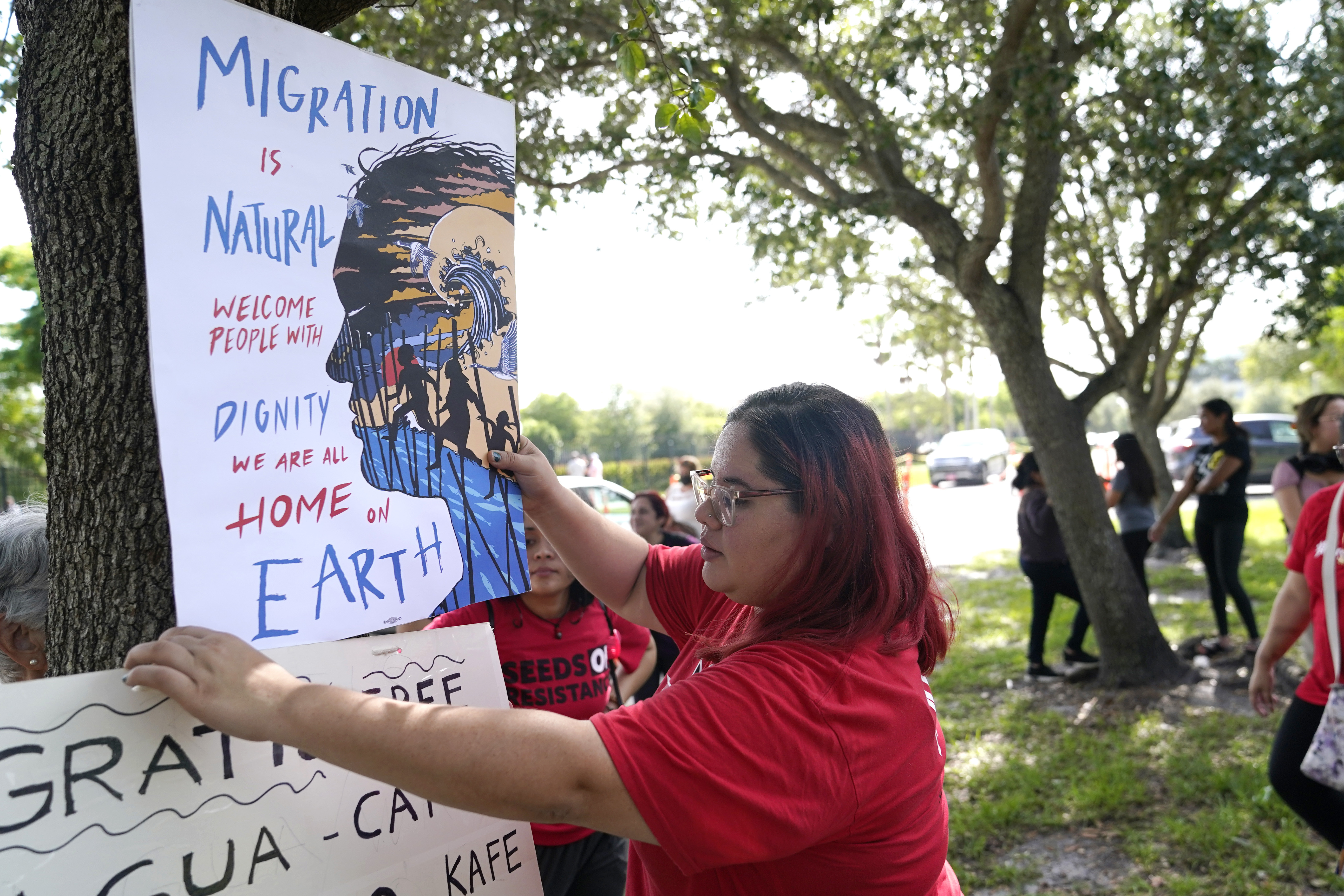 Cynthia Moreno, 32, hangs a sign across the street from an U.S. Immigration and Customs Enforcement office on June 15, in Miramar, Fla. Immigrant advocates head to a federal appeals court in New Orleans on Wednesday, in hopes of saving an Obama-era program that prevents the deportation of thousands of people brought into the U.S. as children. 