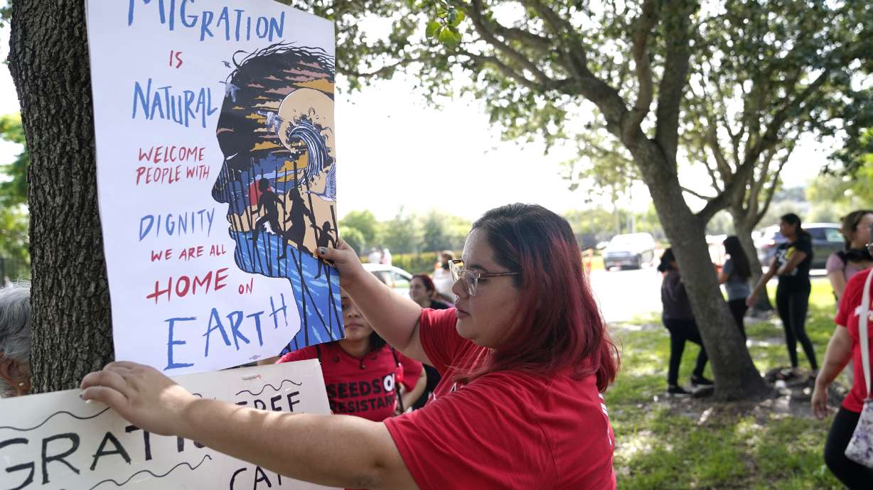 Cynthia Moreno, 32, hangs a sign across the street from an U.S. Immigration and Customs Enforcement office on June 15, in Miramar, Fla. Immigrant advocates head to a federal appeals court in New Orleans on Wednesday, in hopes of saving an Obama-era program that prevents the deportation of thousands of people brought into the U.S. as children.