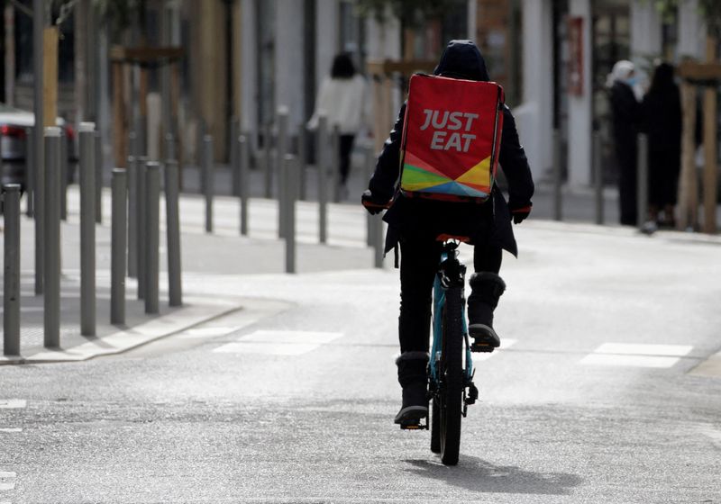 A Just Eat delivery man rides his bicycle in Nice amid the coronavirus disease outbreak in France, Feb. 16, 2021. Amazon has secured the right to buy a 2% stake in Just Eat Takeaway's Grubhub and will offer no-fee access to the service for a year to U.S. Prime members, hoping to boost subscriptions with a renewed push into meal delivery.