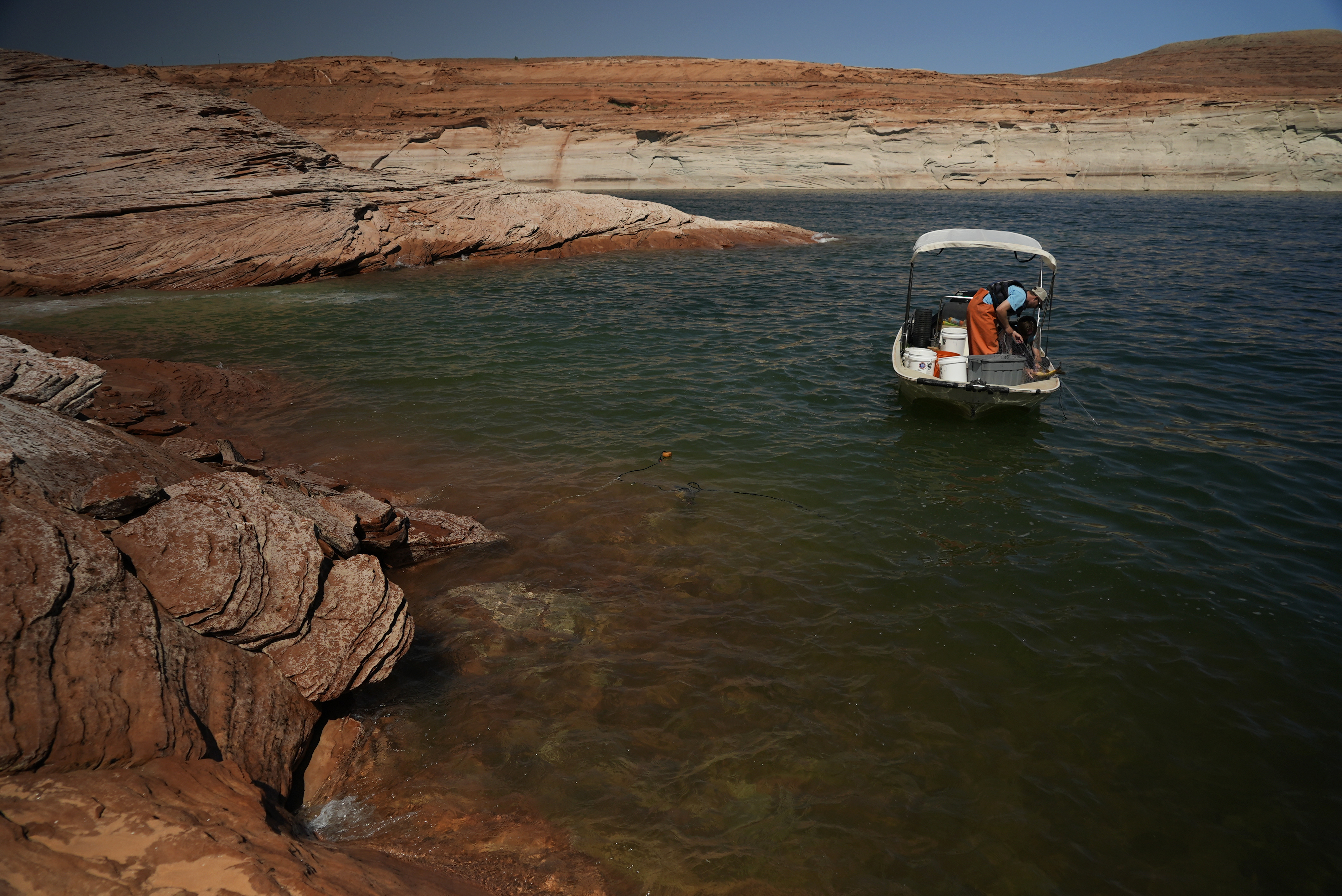A Utah State University research team works at Lake Powell on June 7 in Page, Ariz. Confirming their worst fears for record-low lake levels, National Park Service fisheries biologists have discovered that smallmouth bass, a nonnative predator fish, below the Glen Canyon Dam. Efforts to remove the species will begin on Saturday and Sunday.