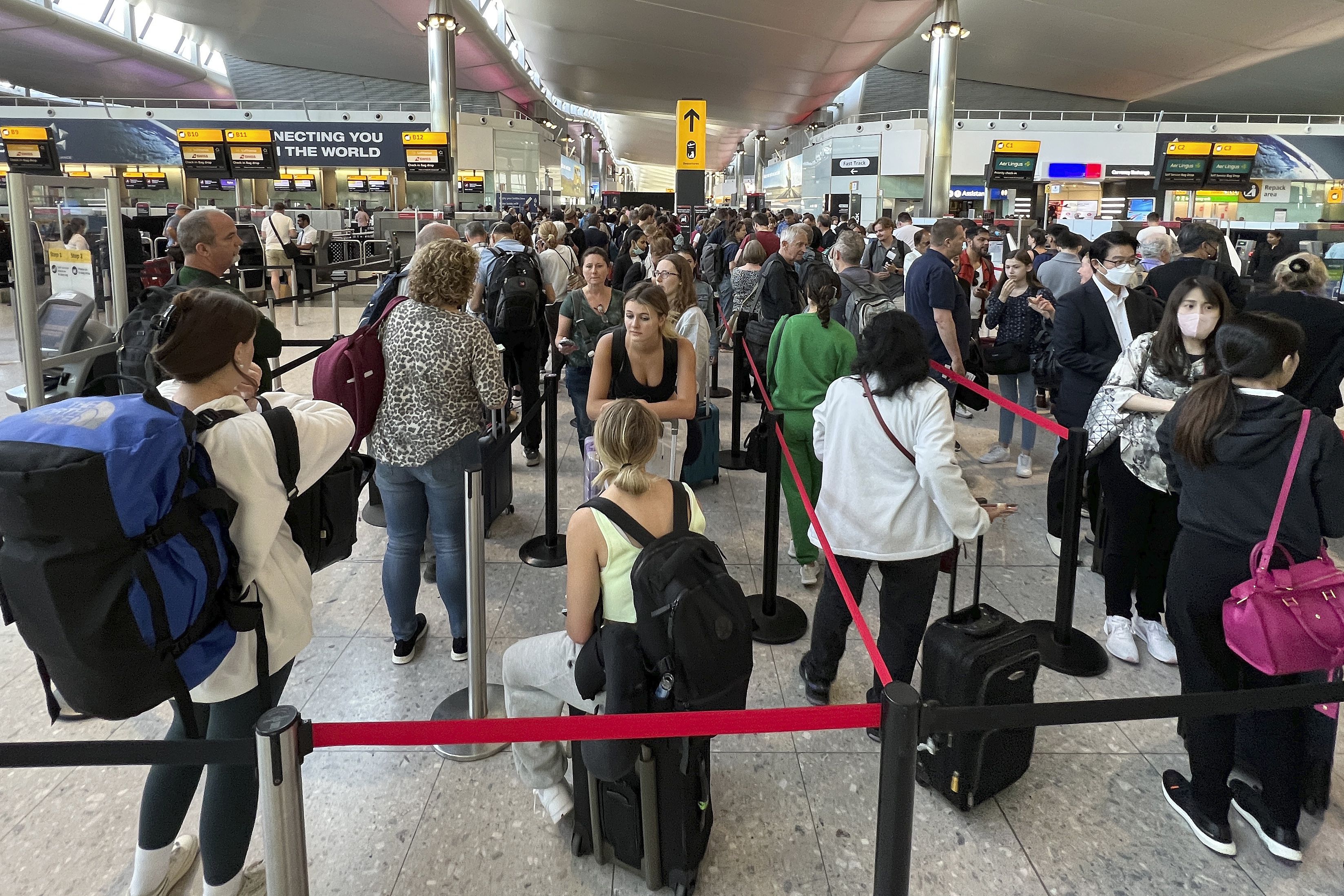 Travelers line up at security at Heathrow Airport in London on June 22. The dollar hit new 20-year highs on Wednesday and the euro tumbled to a new two-decade low as rising energy prices and potential shortages cast a long shadow over the euro zone’s economy, according to Reuters.