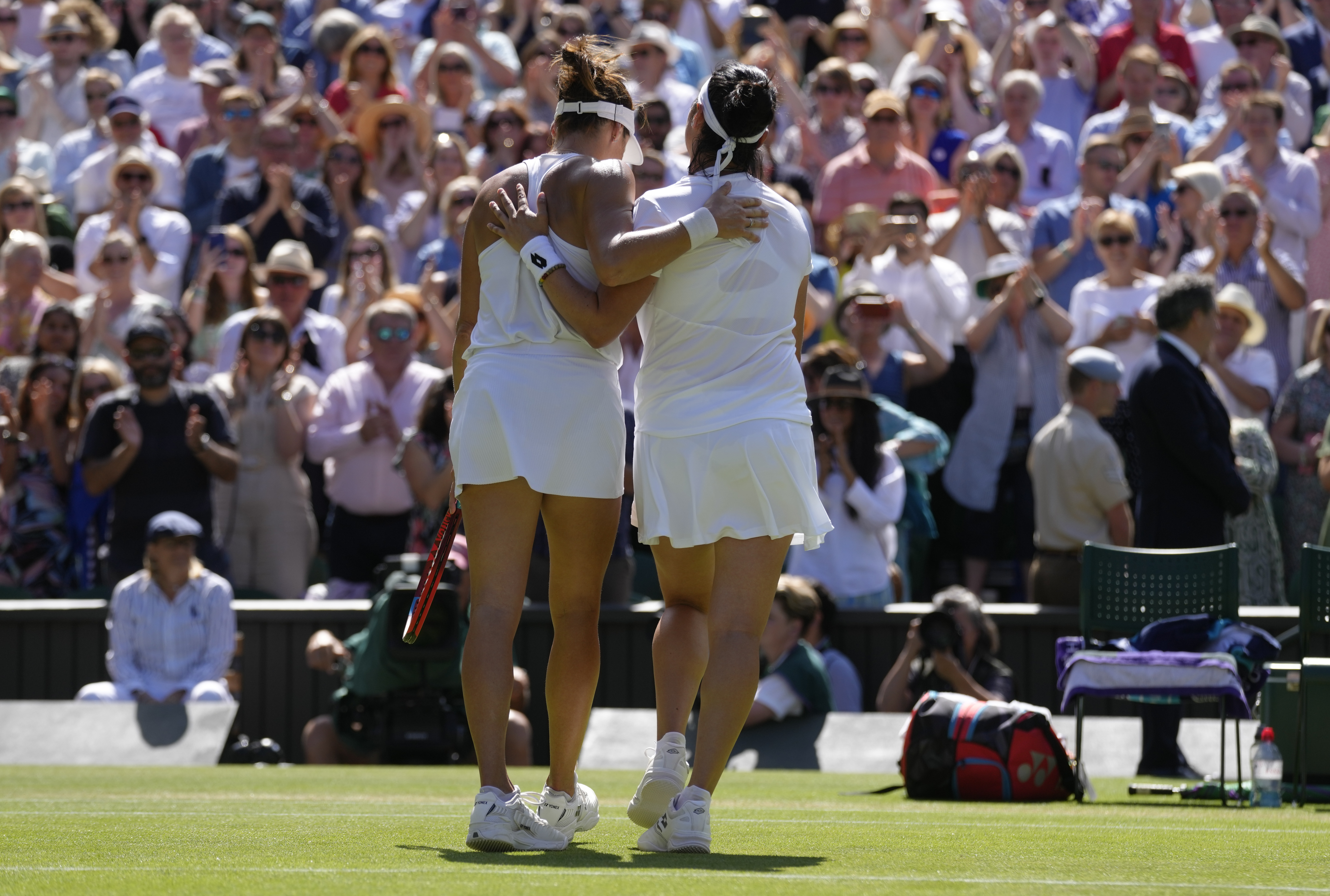 Tunisia's Ons Jabeur, right, embraces Germany's Tatjana Maria after beating her in a women's singles semifinal match on day eleven of the Wimbledon tennis championships in London, Thursday, July 7, 2022.