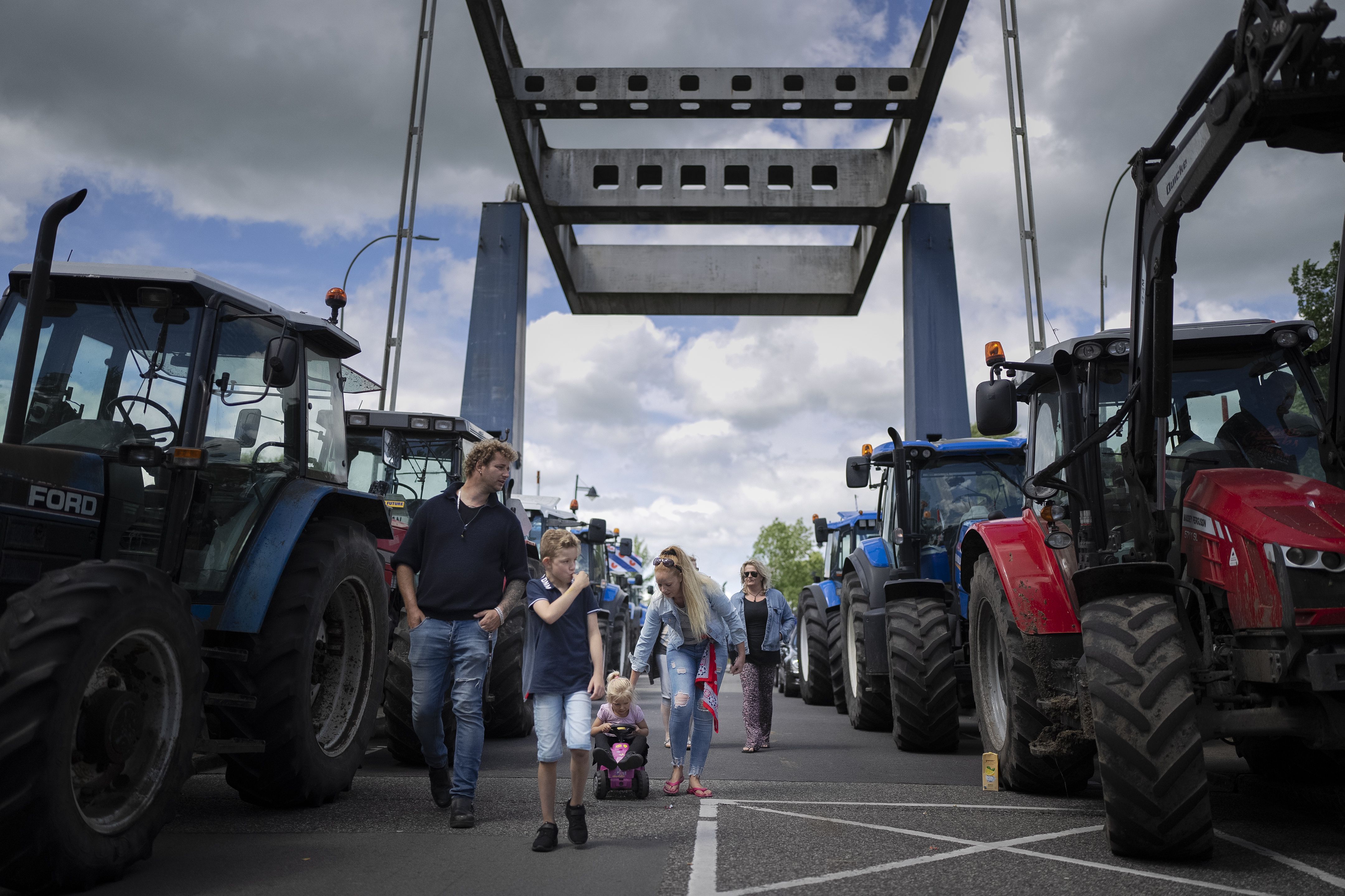 Protesting farmers block a drawbridge at a lock in the Princess Margriet canal, preventing all ship traffic from passing in Gaarkeuken, northern Netherlands, on Monday. Dutch farmers angry at government plans to slash emissions also used tractors and trucks Monday to blockade supermarket distribution centers, the latest actions in a summer of discontent in the country’s lucrative agricultural sector.