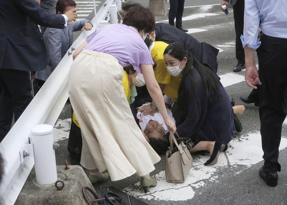 Japan’s former Prime Minister Shinzo Abe, center, falls on the ground in Nara, western Japan Friday. Abe was in heart failure after apparently being shot during a campaign speech Friday in western Japan, NHK public television said Friday.