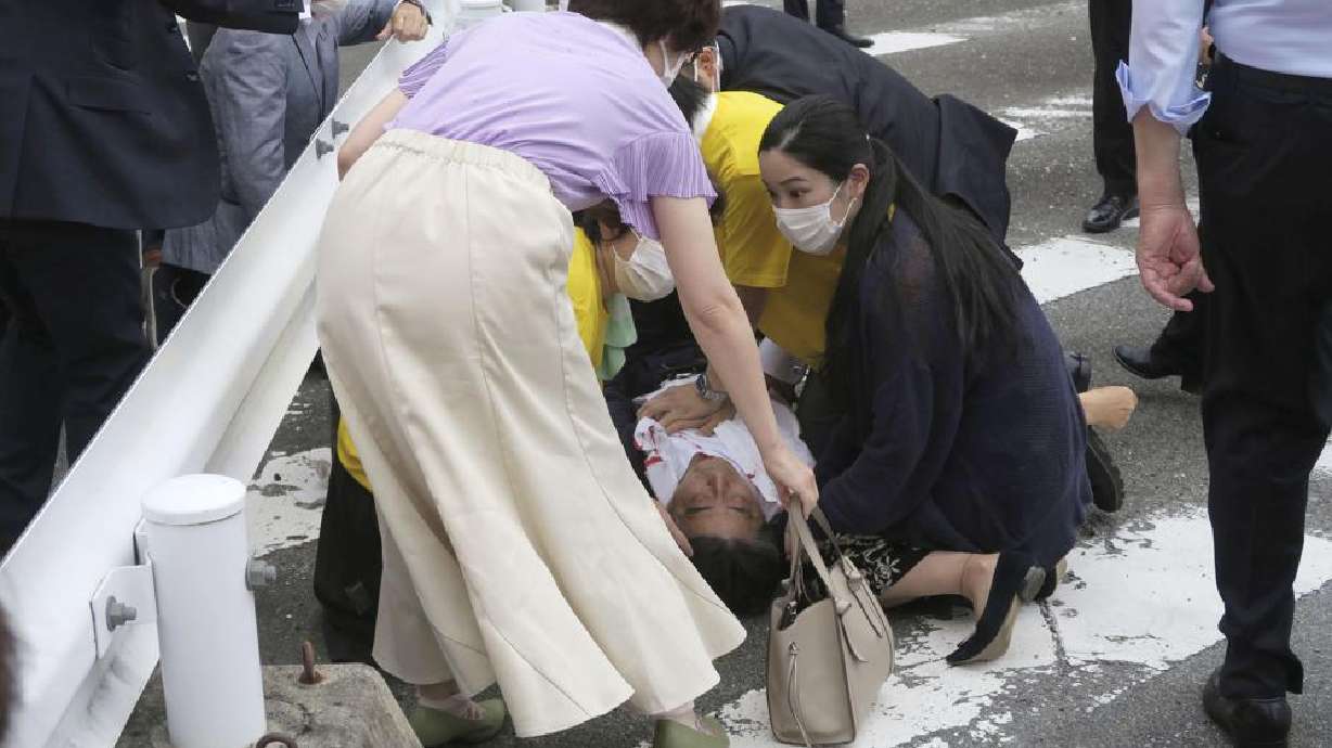 Japan’s former Prime Minister Shinzo Abe, center, falls on the ground in Nara, western Japan Friday. Abe was in heart failure after apparently being shot during a campaign speech Friday in western Japan, NHK public television said Friday.