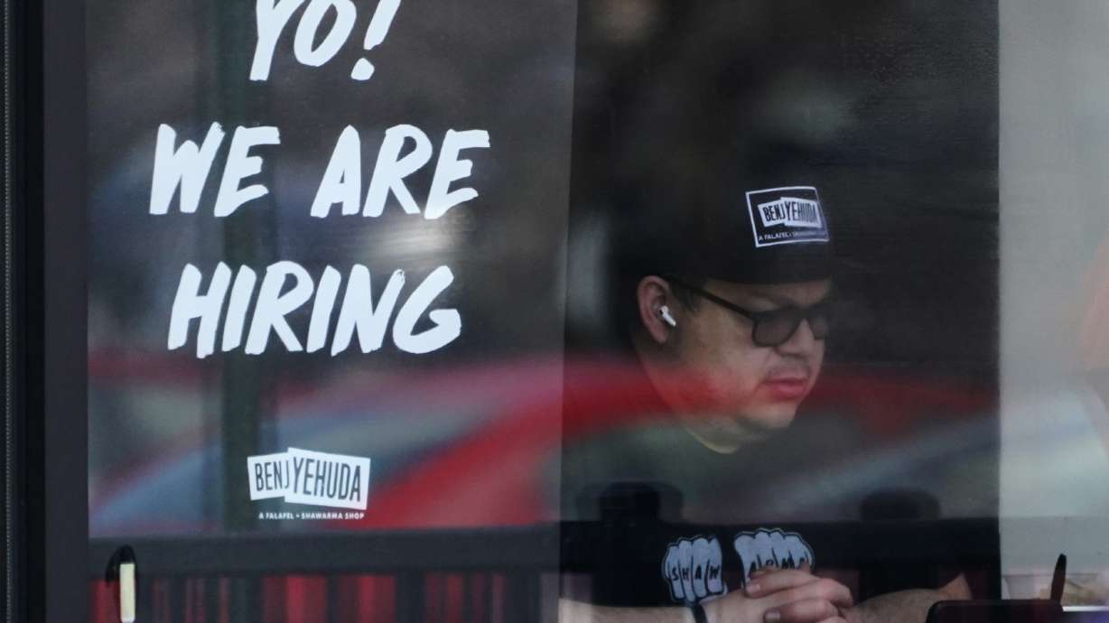 A hiring sign is displayed at a restaurant in Schaumburg, Ill., April 1. America's employers shrugged off high inflation to add 372,000 jobs in June, the Labor Department reported Friday.
