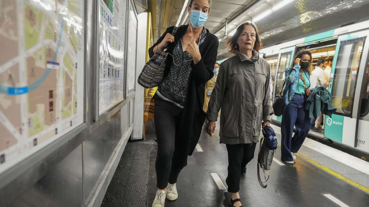 A woman wearing a face mask rushes on a subway platform in Paris on June 30. Virus cases are rising fast in France and other European countries after COVID-19 restrictions were lifted in the spring.