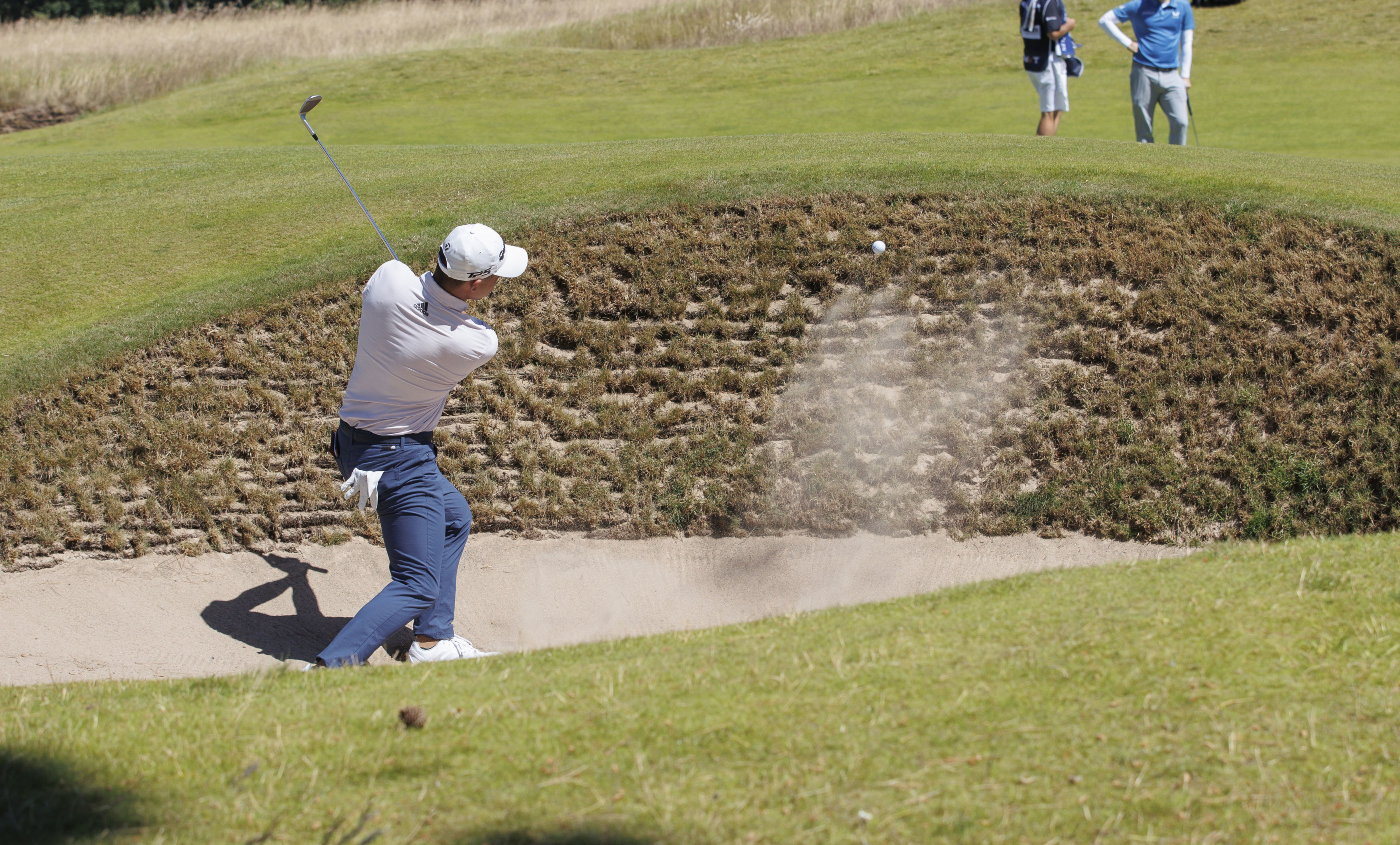 Colin Morikawa from the US plays out of the bunker on the 1st hole during day one of the Scottish Open at The Renaissance Club, North Berwick, Scotland, Thursday July 7, 2022. 