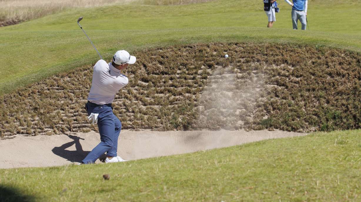 Colin Morikawa from the US plays out of the bunker on the 1st hole during day one of the Scottish Open at The Renaissance Club, North Berwick, Scotland, Thursday July 7, 2022.