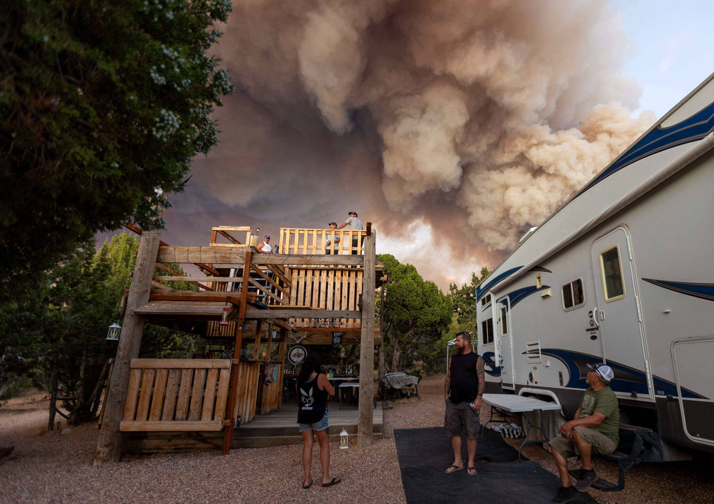 Residents relax after being permitted to go back to their property while a fire burns in Fillmore on Friday.