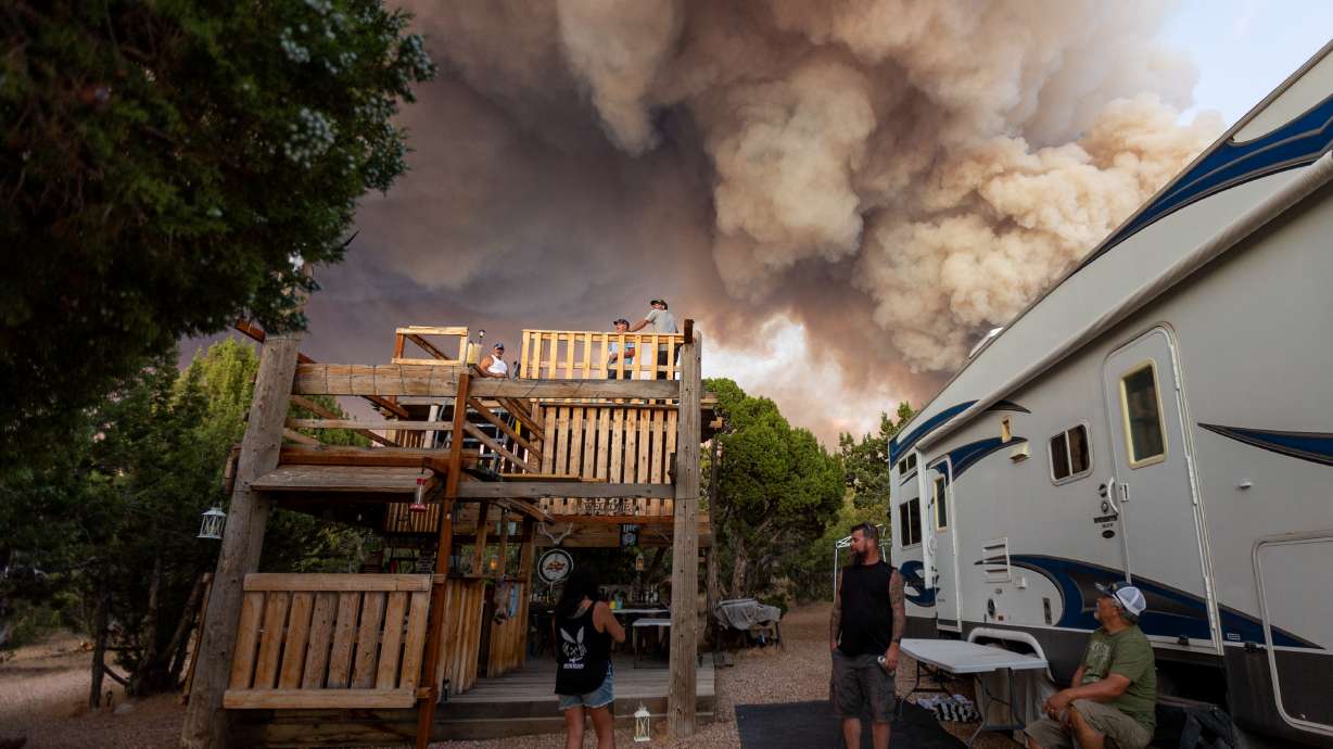 Residents relax after being permitted to go back to their property while a fire burns in Fillmore on Friday.