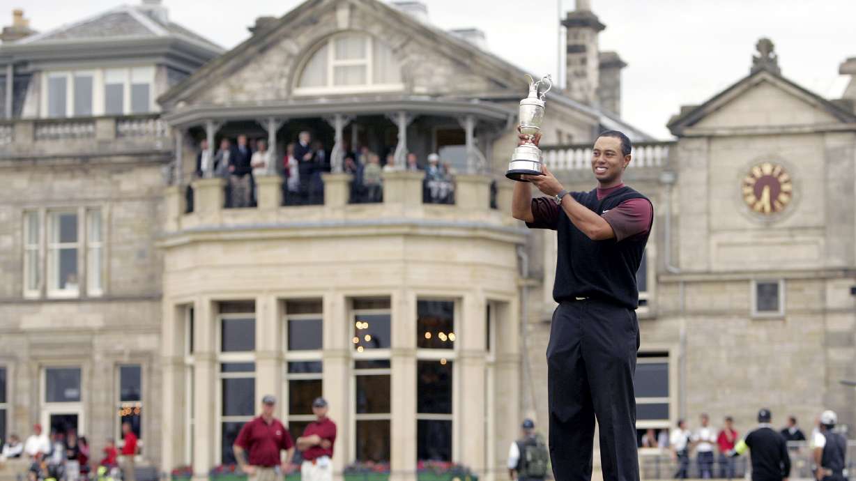 FILE - Tiger Woods holds the trophy as he stands in front of the clubhouse after winning the British Open golf championship on the Old Course at St. Andrews, Scotland, Sunday July 17, 2005. The Open Championship returns to the home of golf on July 14-17, 2022, to celebrate the 150th edition of the sport's oldest championship, which dates to 1860 and was first played at St. Andrews in 1873.