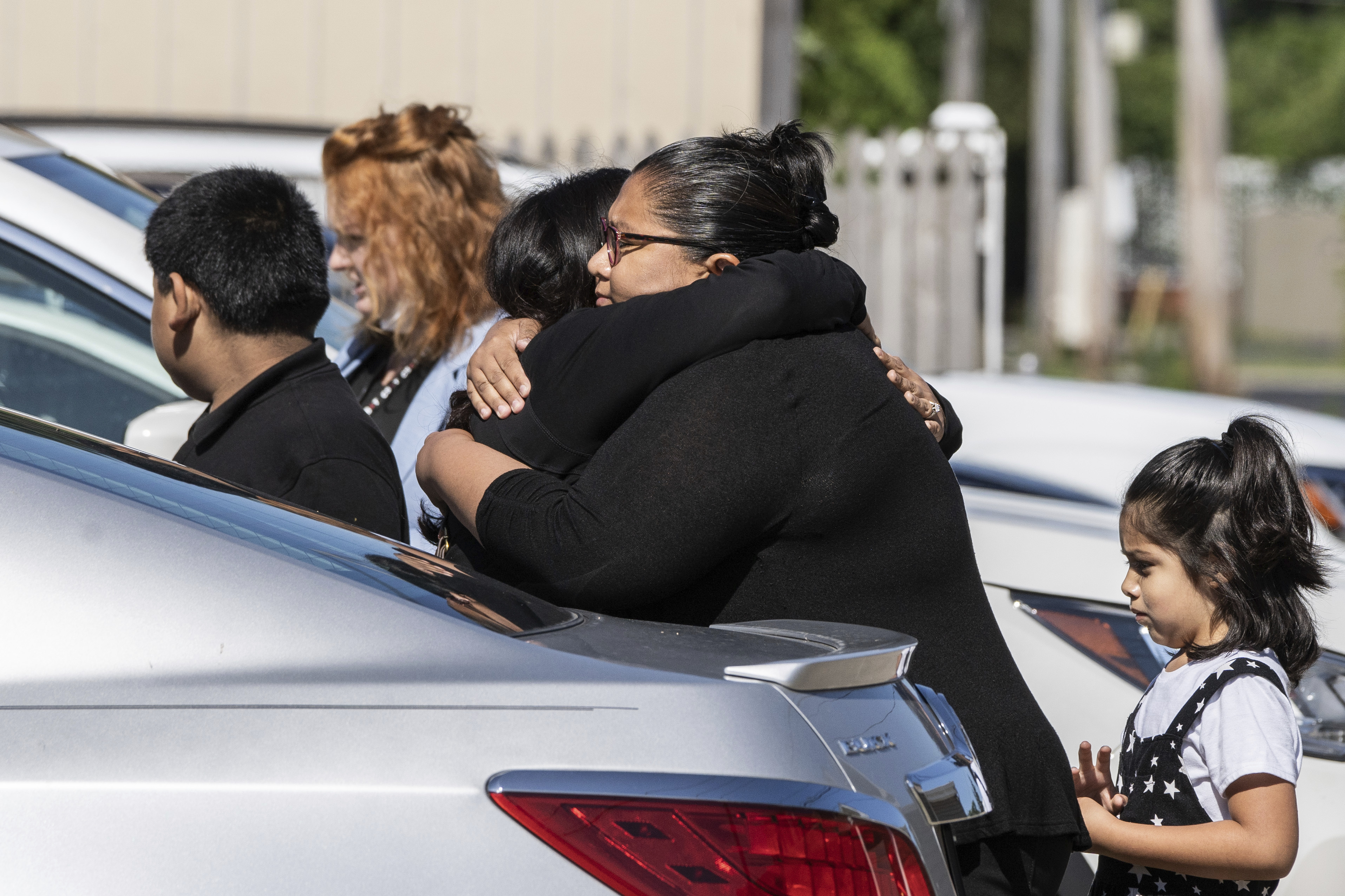 Mourners hug outside Memorial Chapel Funeral Home in Waukegan, Ill., Saturday, during funeral services for Eduardo Uvaldo, who was killed Monday during a mass shooting at the Fourth of July parade in Highland Park.