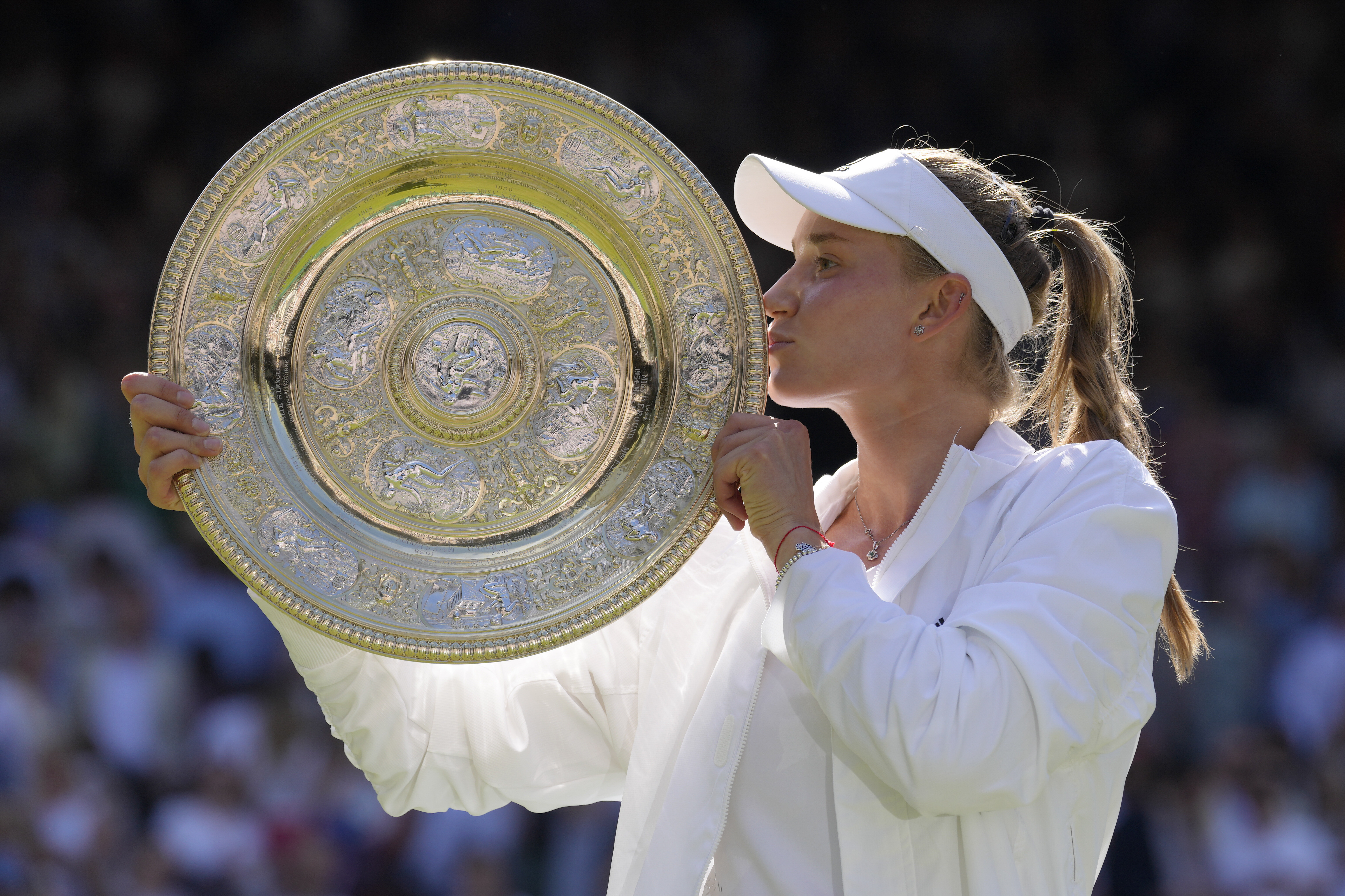 Kazakhstan's Elena Rybakina kisses the trophy as she celebrates after beating Tunisia's Ons Jabeur to win the final of the women's singles on day thirteen of the Wimbledon tennis championships in London, Saturday, July 9, 2022.