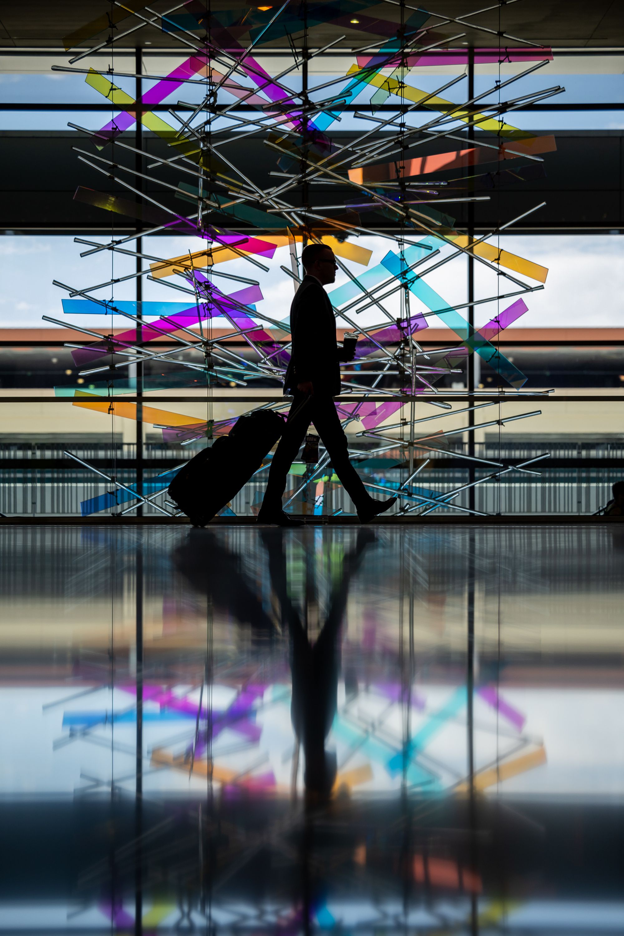 A traveler walks past “The Falls” sculpture at Salt Lake City International Airport in Salt Lake City on July 1. A majority of Utah residents are now considering scaling back or postponing summer travel plans in the face of ongoing inflationary pressures and record-high gas prices, according to new polling data.