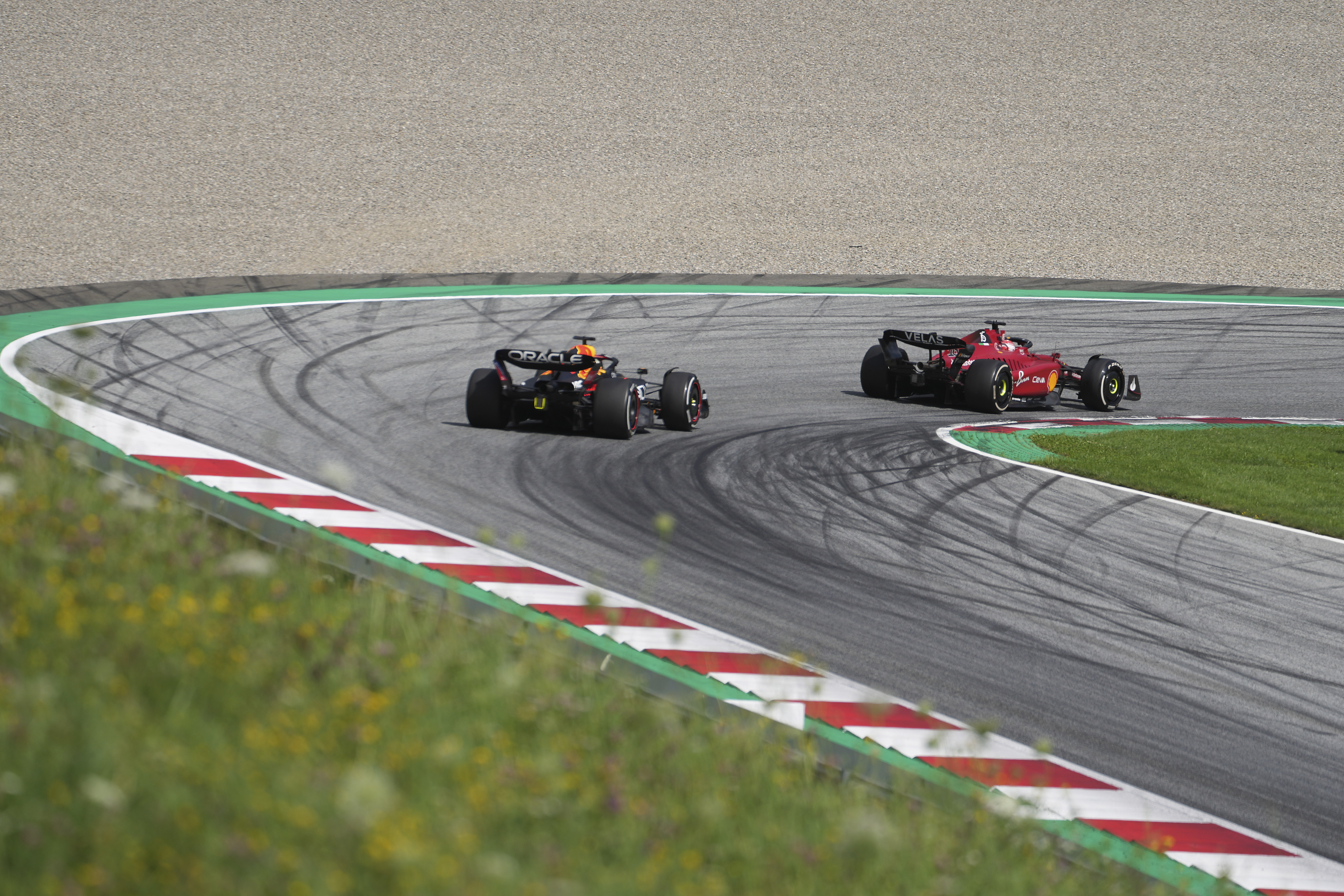 Ferrari driver Charles Leclerc, right, of Monaco, steers his car followed by Red Bull driver Max Verstappen, of the Netherlands, during the Austrian F1 Grand Prix at the Red Bull Ring racetrack in Spielberg, Austria, Sunday, July 10, 2022. 