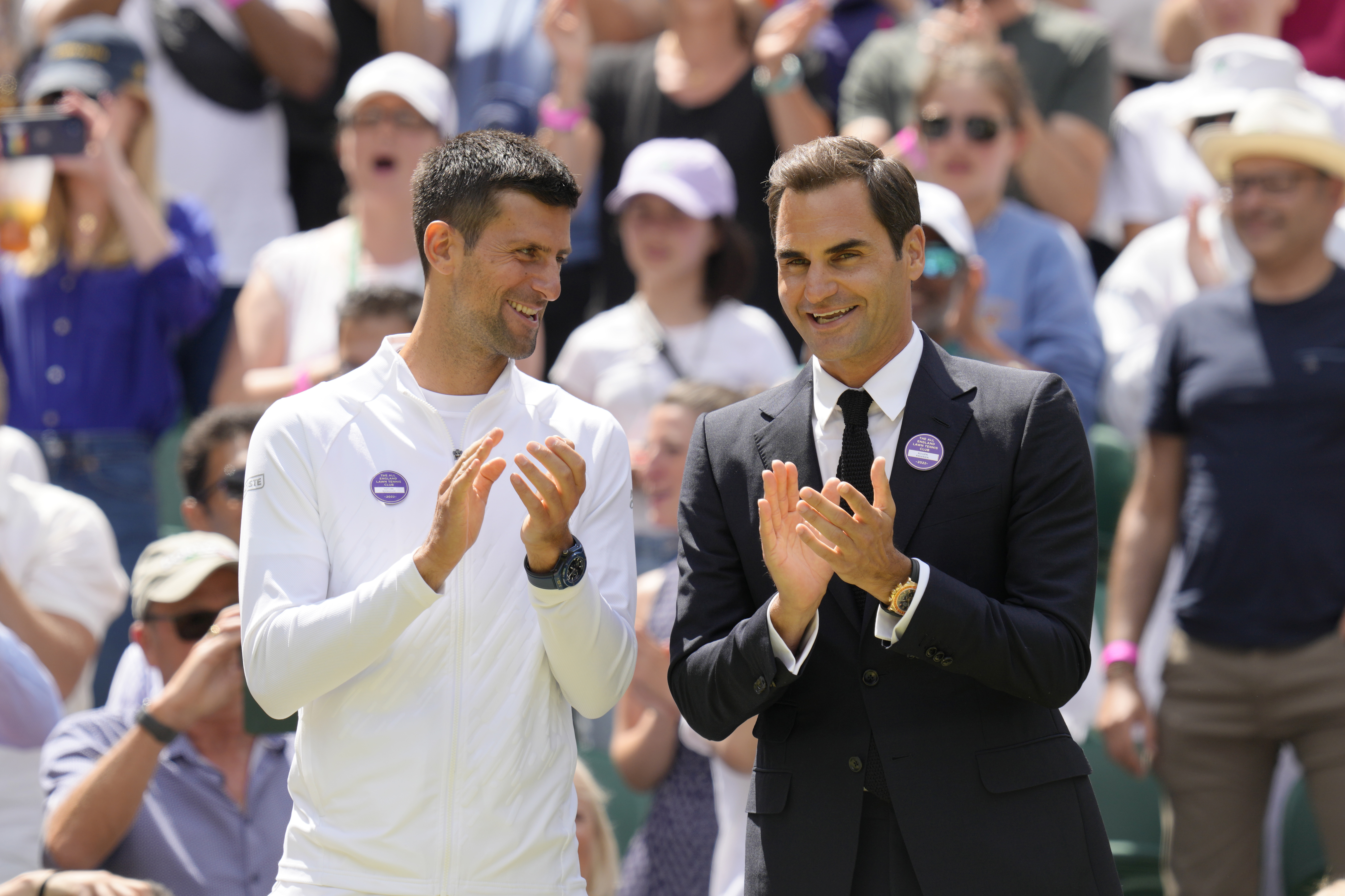 Serbia's Novak Djokovic and Switzerland's Roger Federer applaud during a 100 years of Centre Court celebration on day seven of the Wimbledon tennis championships in London, Sunday, July 3, 2022. 