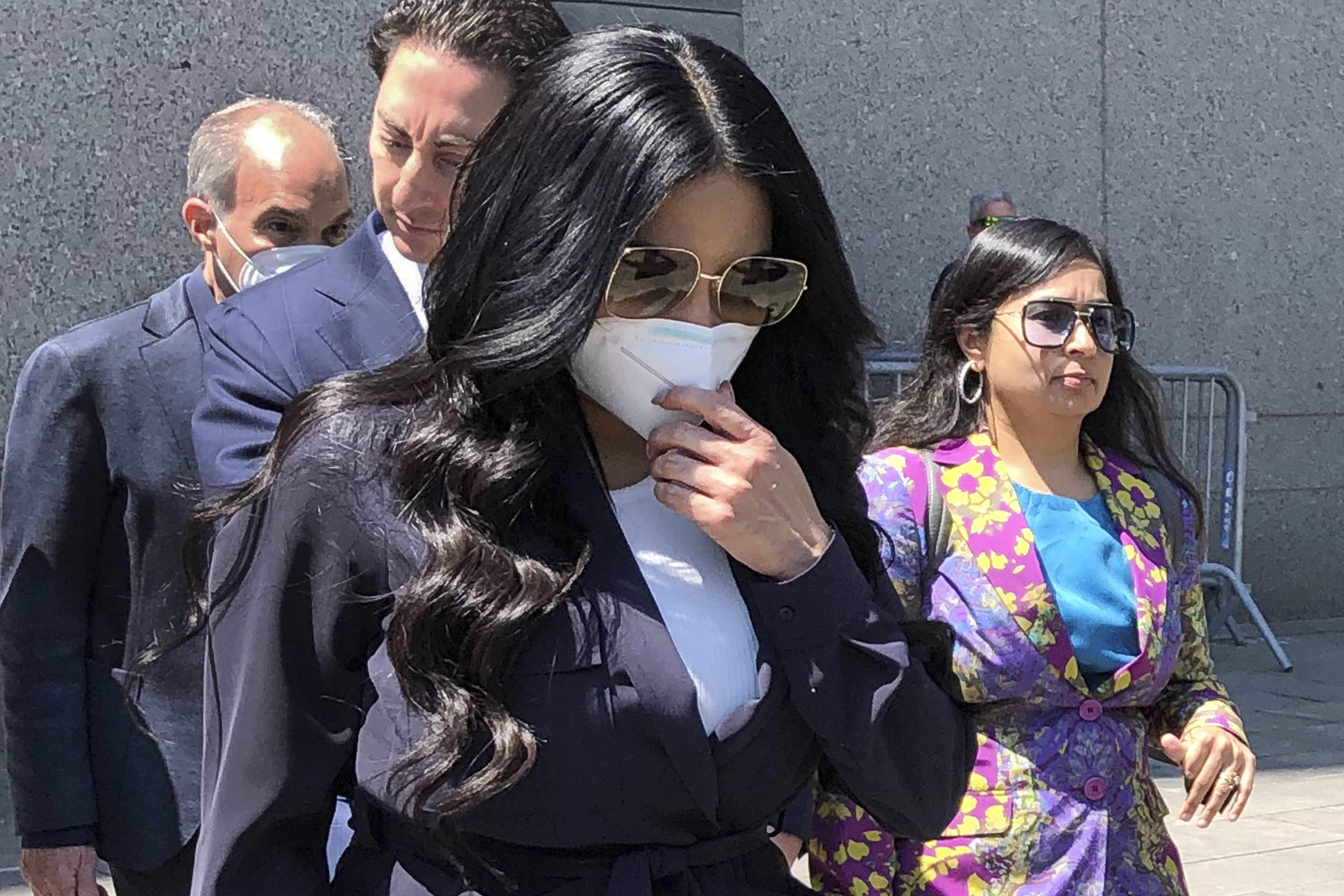 Jennifer Shah, center, of "The Real Housewives of Salt Lake City" reality television series, touches her face mask as she leaves Manhattan federal court, after pleading guilty to wire fraud conspiracy, in New York, Monday. She admitted that she and others defrauded thousands of individuals nationwide for almost a decade with a telemarketing fraud that convinced victims they could make a lot of money through their own online businesses. 