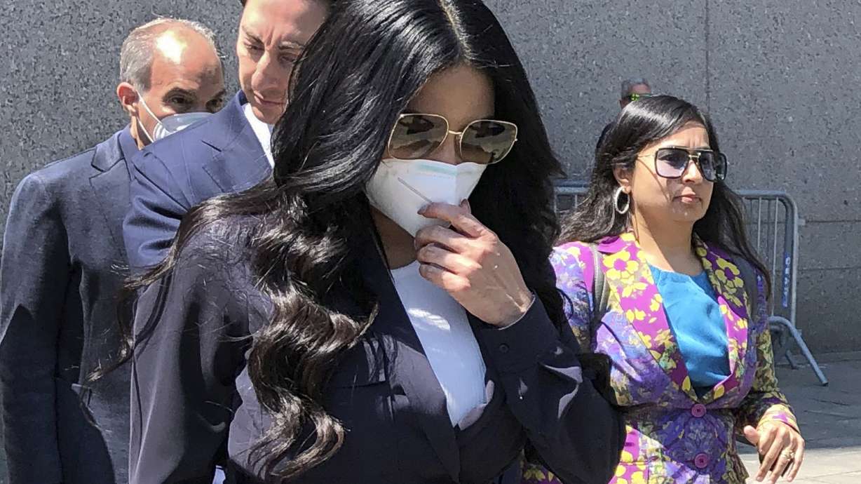 Jennifer Shah, center, of "The Real Housewives of Salt Lake City" reality television series, touches her face mask as she leaves Manhattan federal court, after pleading guilty to wire fraud conspiracy, in New York, Monday. She admitted that she and others defrauded thousands of individuals nationwide for almost a decade with a telemarketing fraud that convinced victims they could make a lot of money through their own online businesses.