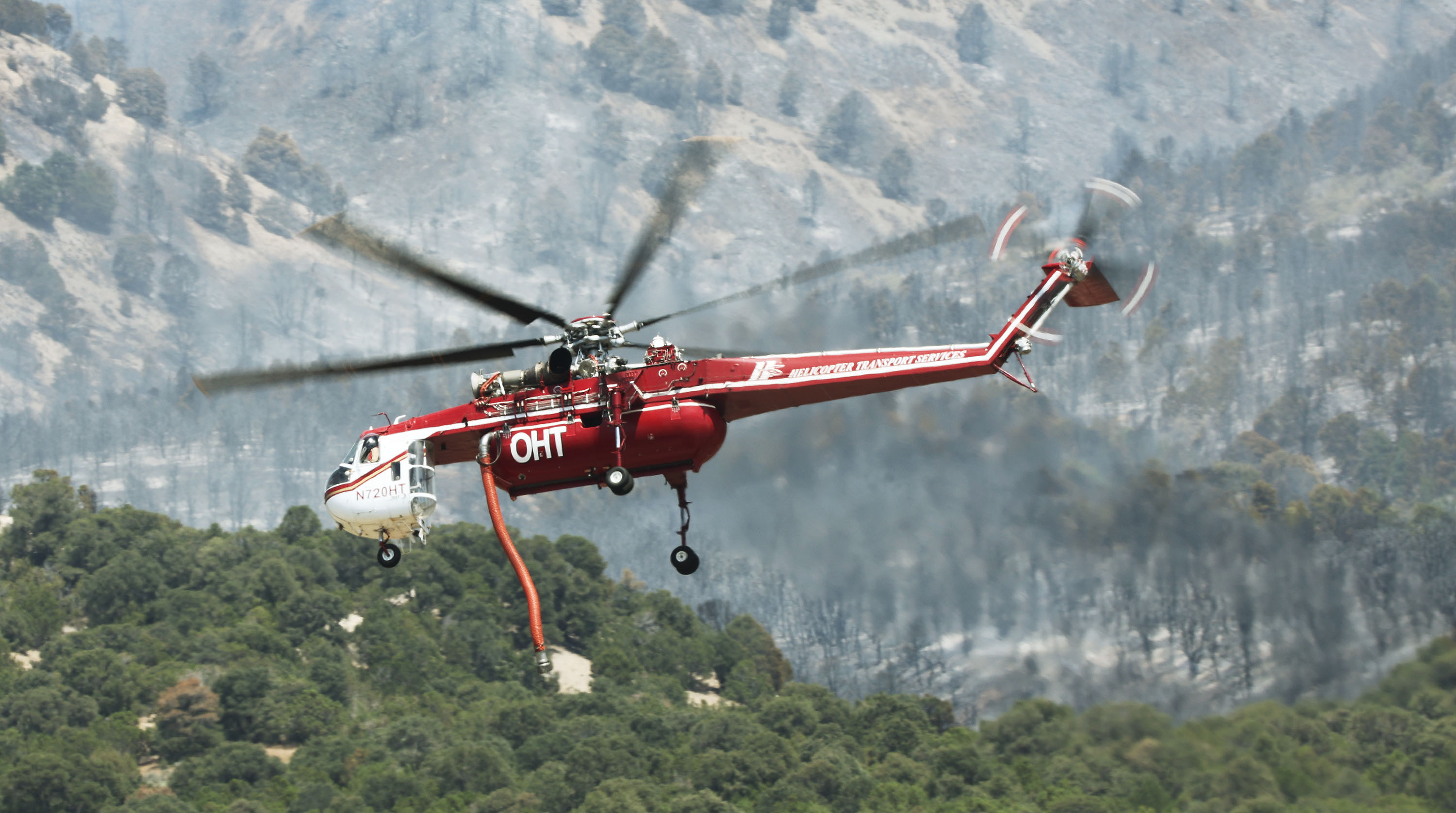 A helicopter picks up water to fight the Jacob City Fire near Stockton, Tooele County, on Monday.
