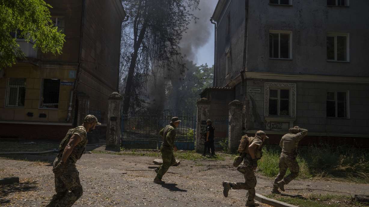 Ukrainian soldiers run after a missile strike hit a residential area, in Kramatorsk, Donetsk region, eastern Ukraine, Thursday. Ukrainian authorities say their forces targeted a Russian ammunition depot in southern Ukraine overnight, resulting in a massive explosion captured on social media.