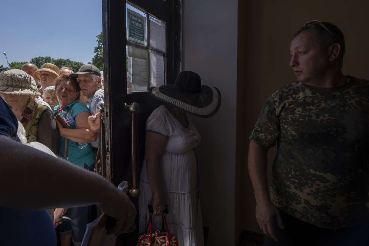 People who mostly refuse to evacuate their homes, wait in line to receive humanitarian food aid from the Kramatorsk city council, eastern Ukraine, Thursday.