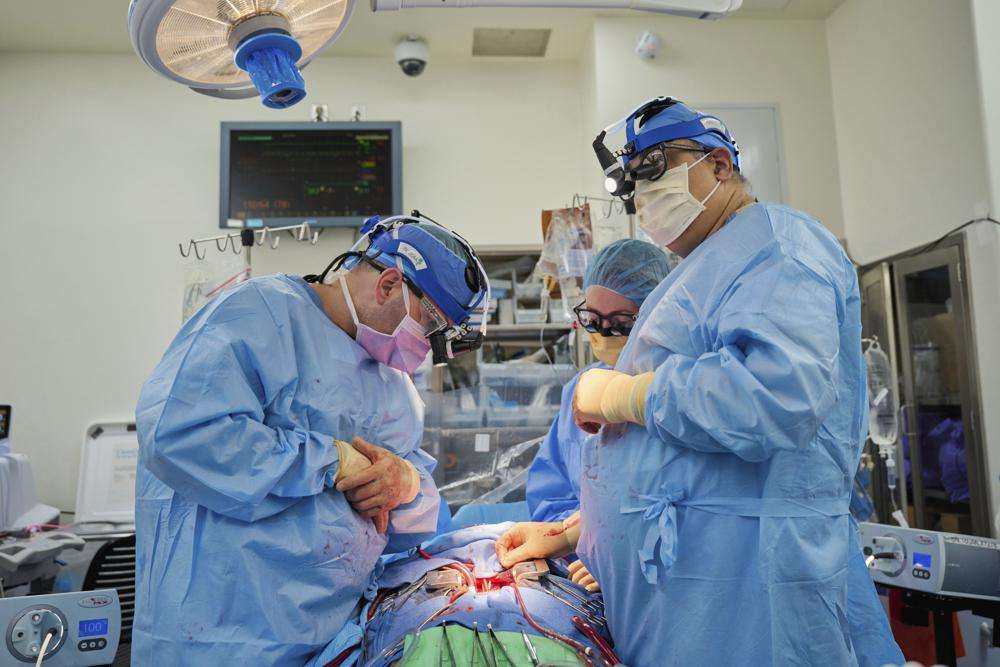 Dr. Nader Moazami, right, and cardiothoracic physician assistant Amanda Merrifield, center, and other members of a surgical team prepare for the transplant of a genetically modified pig heart into a recently deceased donor at NYU Langone Health on July 6 in New York.