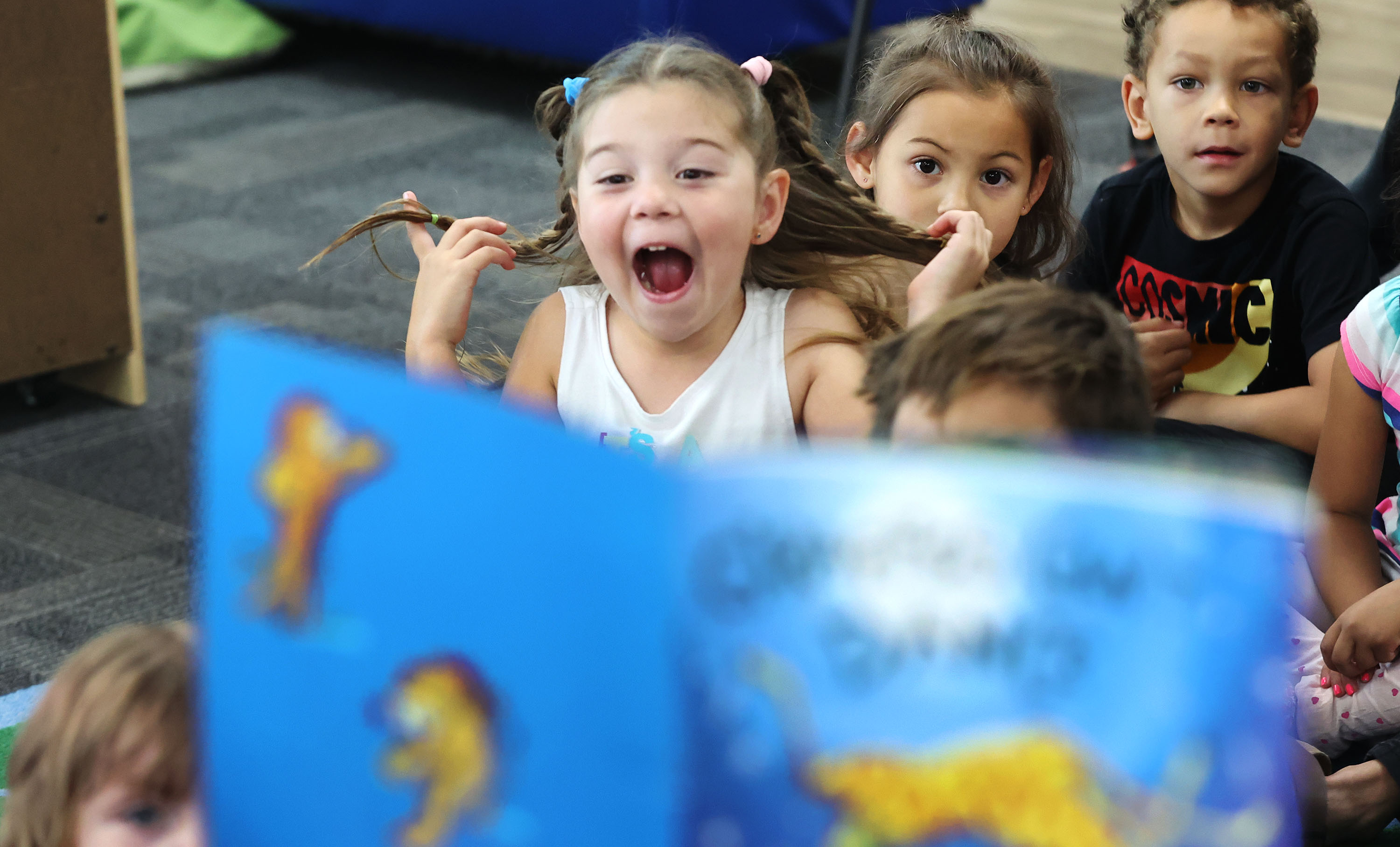 Charlotte, 5, reacts as Lt. Gov. Deidre Henderson reads a book to Creative Learning Academy children in Salt Lake City on Tuesday. Henderson announced a bonus to youth and early care workforce members, offered through the Office of Child Care.
