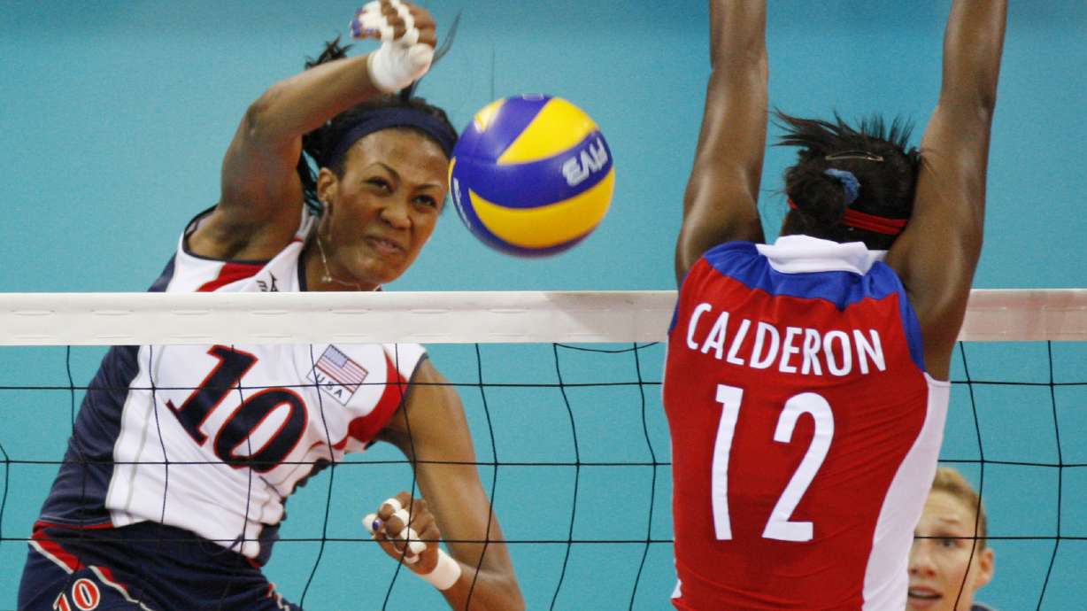 FILE - USA's Kim Glass, left, jumps for the ball with Cuba wing spiker Rosir Calderon during a women's Volleyball match at the Olympics in Beijing on Aug. 11, 2008. A former Olympic volleyball player was attacked Friday, July 8, 2022, in downtown Los Angeles when a man threw a metal object at her face in an assault that fractured bones in her face and left one of her eyes swollen shut, the athlete said in videos posted to social media. Glass, a silver medalist at the 2008 Beijing Olympics, had been leaving a lunch on Friday afternoon when she saw a man run up with something in his hand.