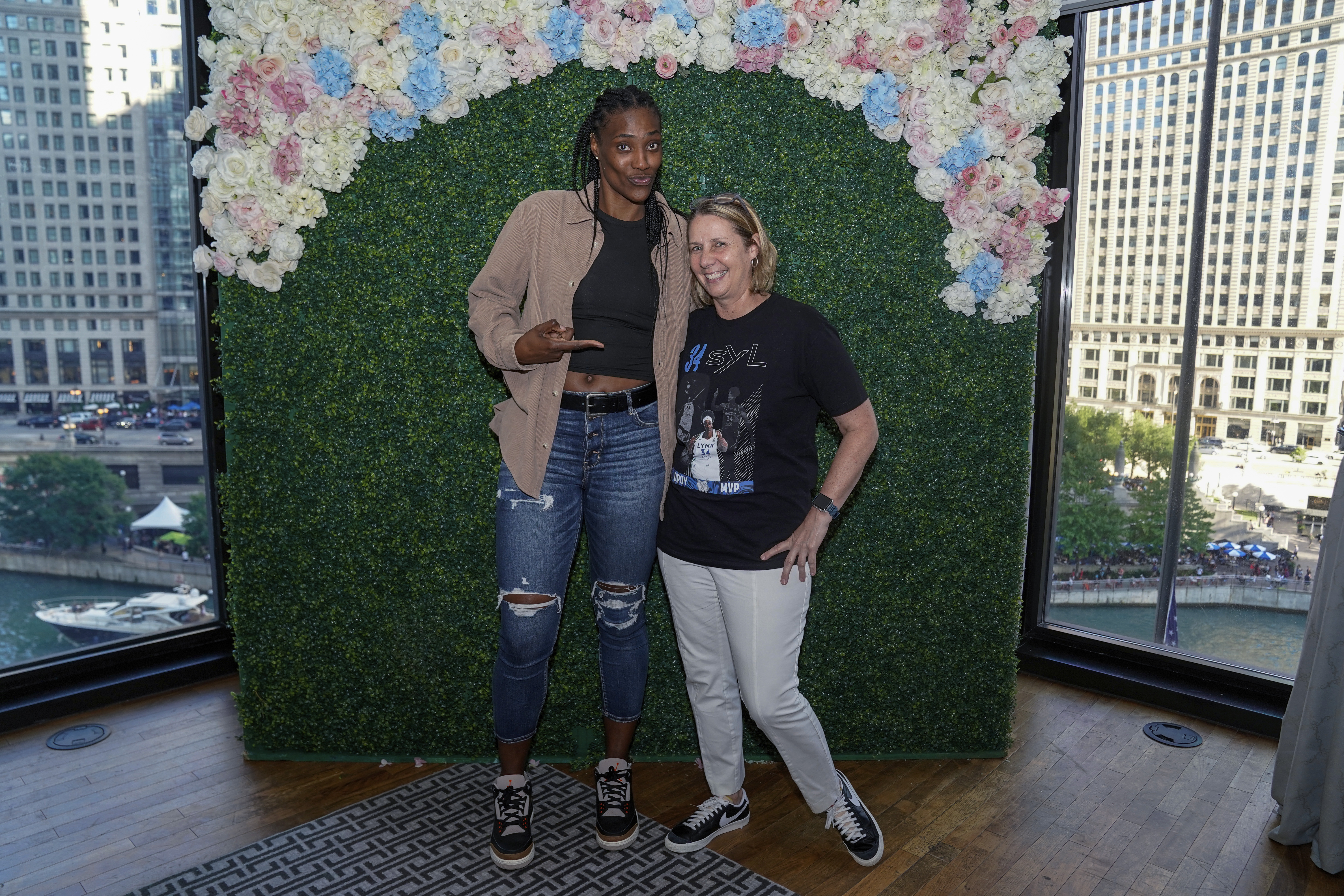In a photo provided by the Minnesota Lynx, Minnesota Lynx's Sylvia Fowles, left, poses for a photo with Lynx coach Cheryl Reeve at a tea party Saturday, July 9, 2022, at a hotel in Chicago. 