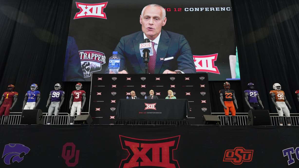 Incoming Big 12 Commissioner Brett Yormark, center, speaks with outgoing Commissioner Bob Bowlsby, left, and Baylor President Linda Livingstone looking on during a news conference opening the NCAA college football Big 12 media days in Arlington, Texas, Wednesday, July 13, 2022.