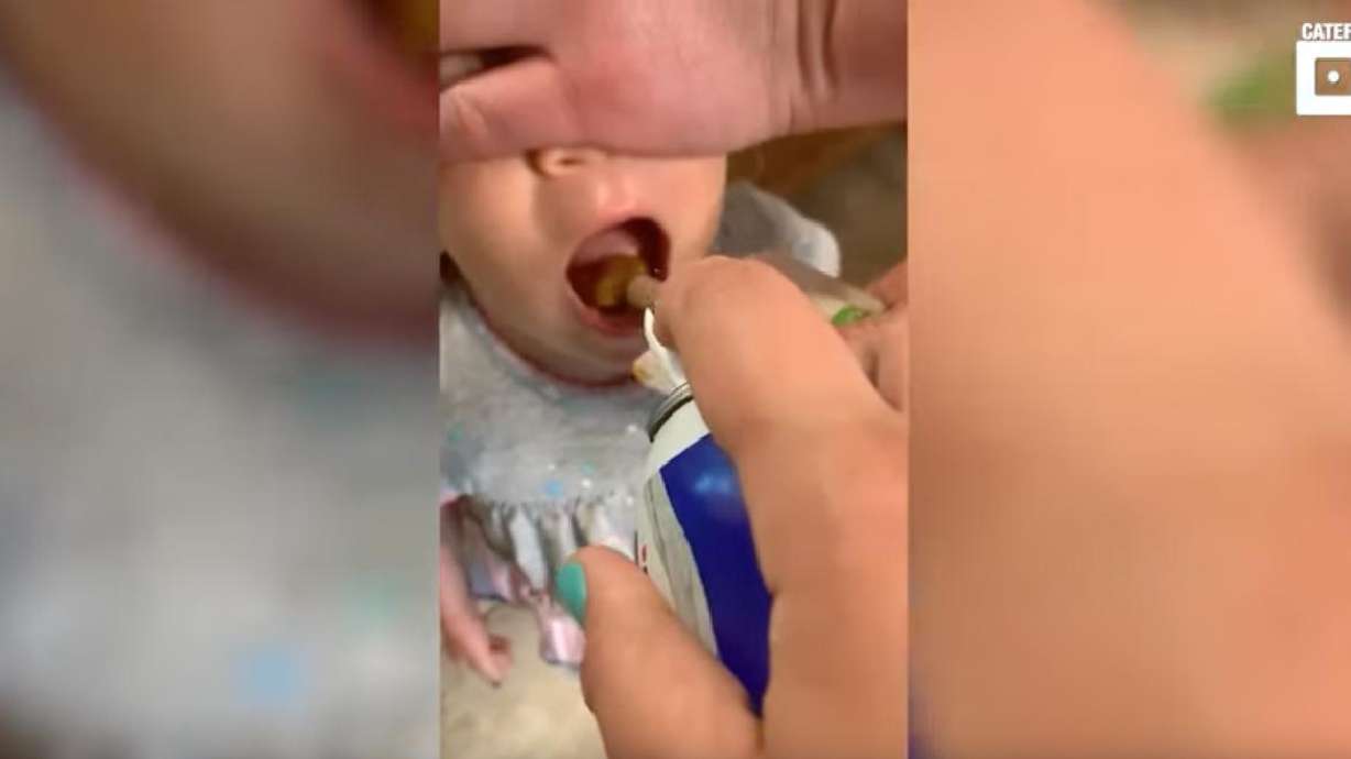 A toddler gets tricked into eating vegetables through the use of a can of whipped cream.