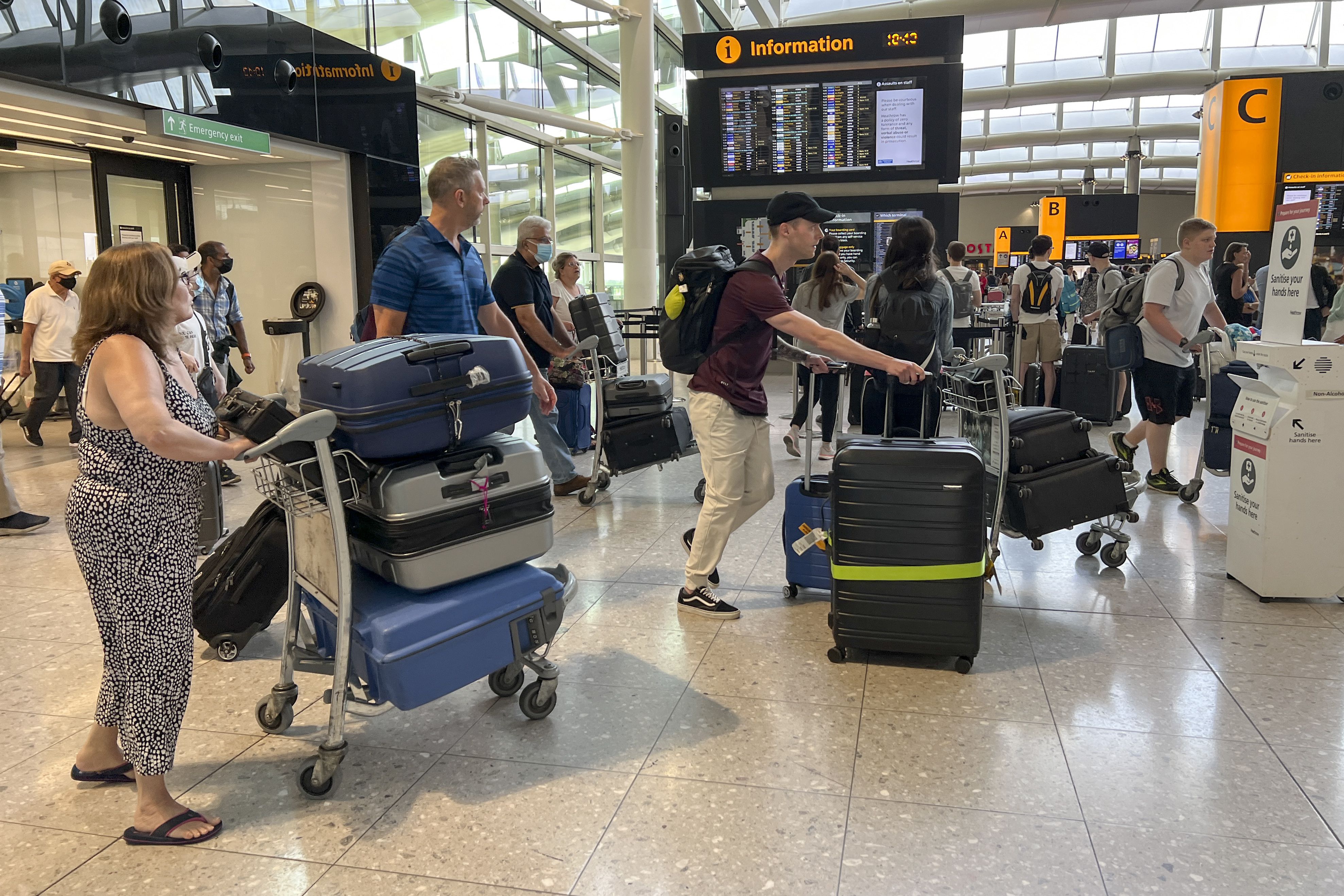 Travellers at Heathrow airport, in London, Wednesday. Heathrow Airport has introduced a cap on passenger numbers this summer as the aviation sector struggles to cope with demand for travel. No more than 100,000 daily passengers will be able to depart from July 12 until Sept. 11, the west London airport announced.