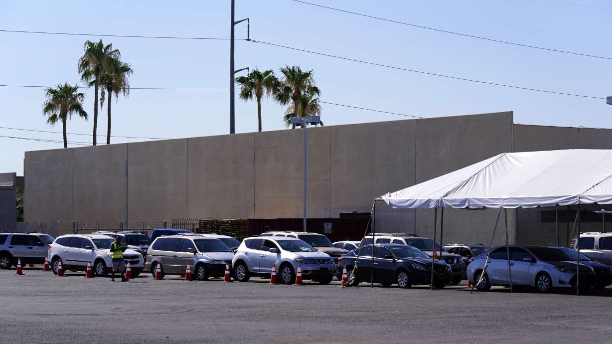 Dozens of vehicles line up to get food boxes at the St. Mary's Food Bank on June 29 in Phoenix. Long lines are back outside food banks around the U.S. as working Americans overwhelmed by inflation increasingly seek handouts to feed their families.