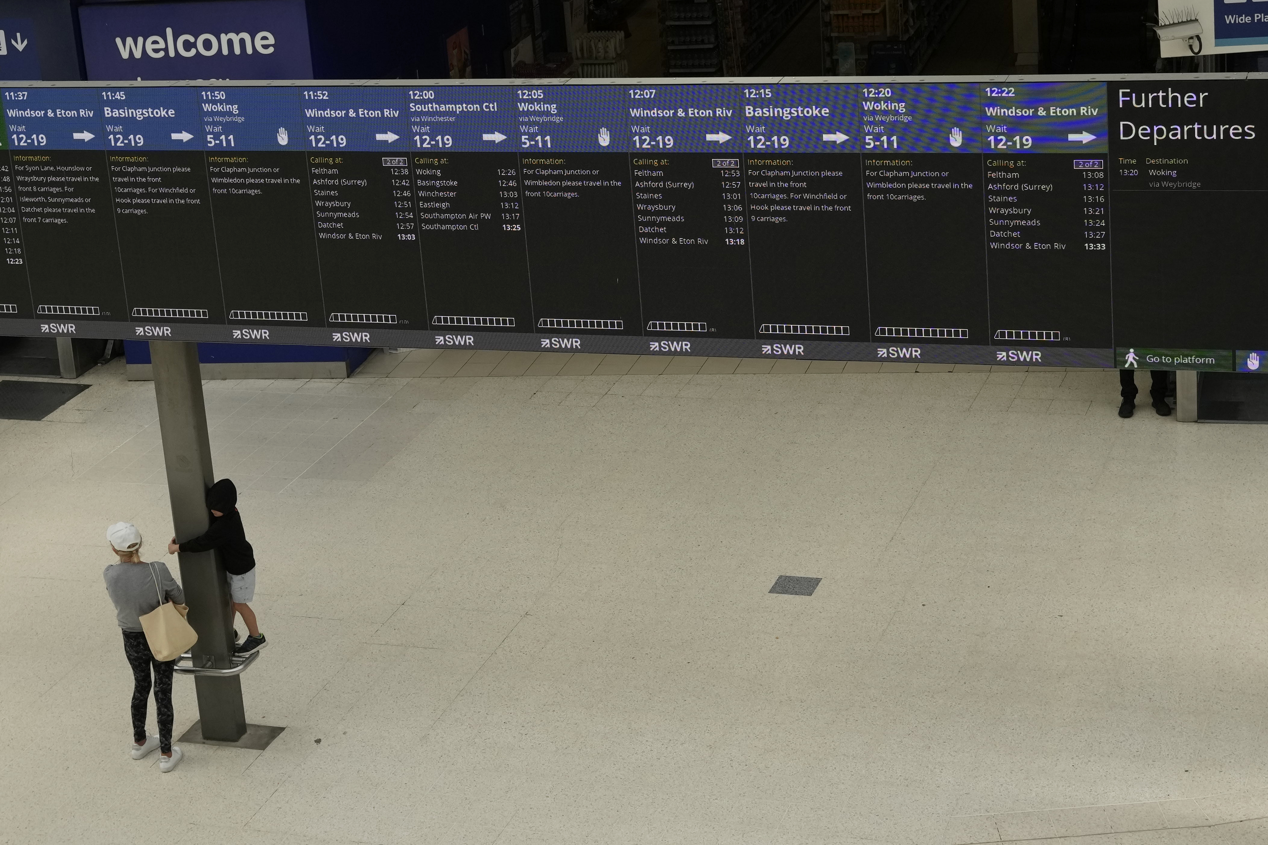 Train departure screens show which services are running, inside a much quieter than normal Waterloo railway station, in London, during a strike held by railway workers, Saturday, June 25, 2022. Train stations are all but deserted across Britain on the third day of a national strike that snarled the weekend plans of millions. Train companies said only a fifth of passenger services would run on Saturday.  