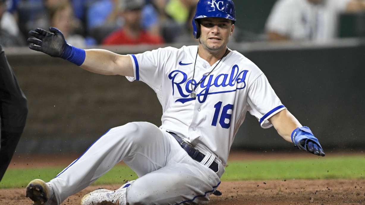 Kansas City Royals' Andrew Benintendi slides across home plate to score against the Detroit Tigers during the eighth inning of a baseball game, Tuesday, July 12, 2022, in Kansas City, Mo.
