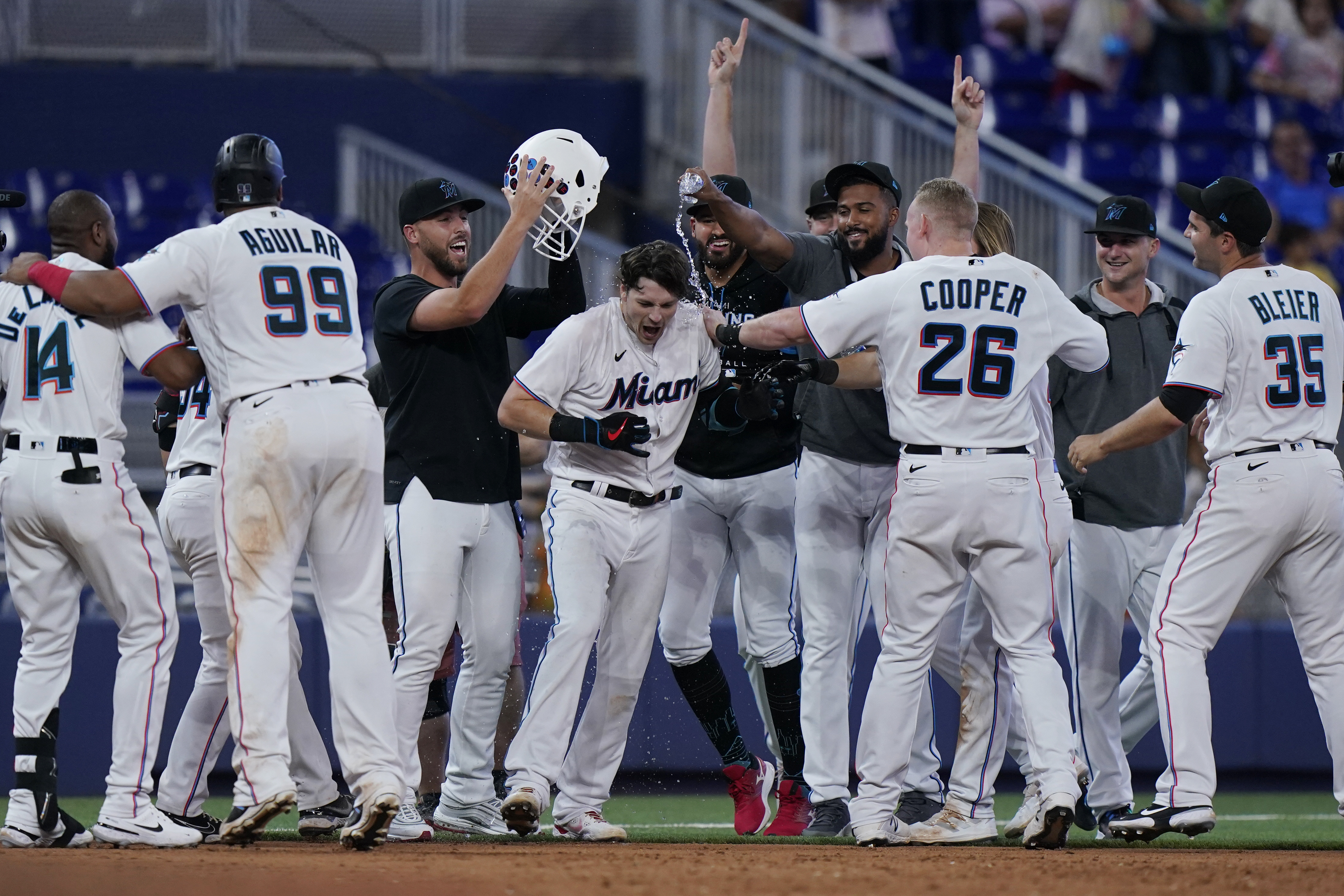 Teammates mob Miami Marlins' Brian Anderson, center, after Anderson tripled scoring Jesus Aguilar and Avisail Garcia during the 11th inning of a baseball game against the Pittsburgh Pirates, Thursday, July 14, 2022, in Miami. 