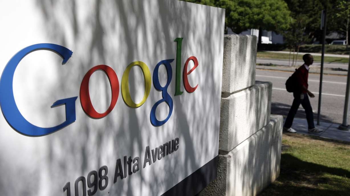 A man walks past a Google sign at the company’s headquarters in Mountain View, California, on June 5, 2014.