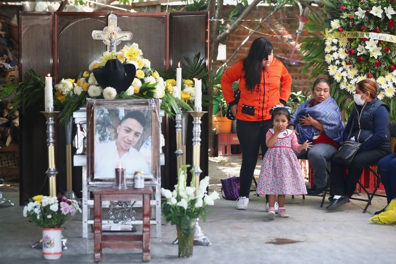 Relatives of late migrant Efrain Ferrel, 22, attend his wake, after being repatriated from San Antonio, Texas, at his family's home in Celaya, in Guanajuato state, Mexico, Thursday.