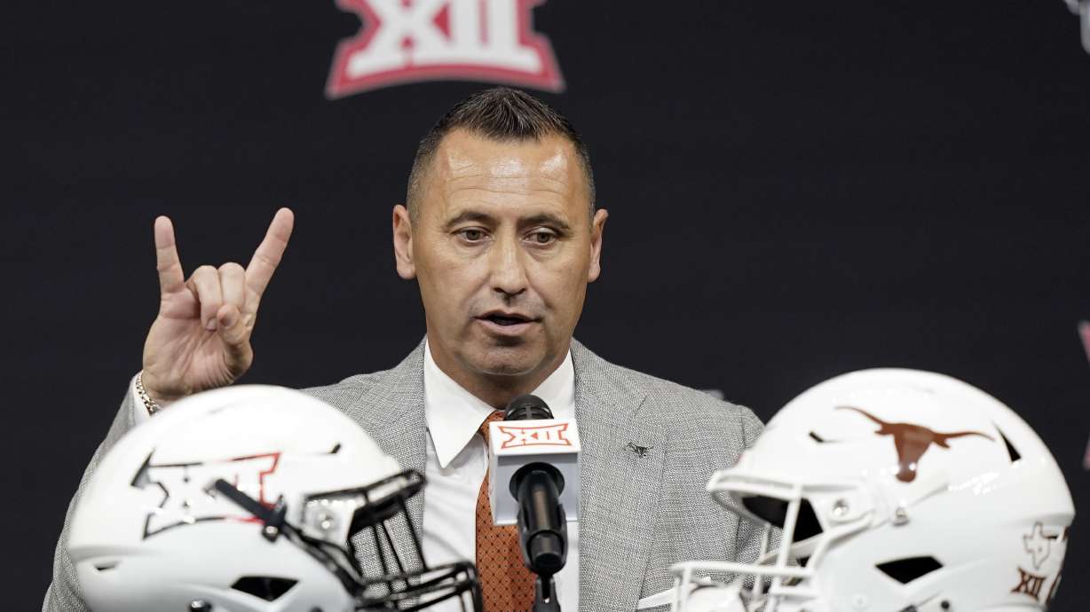 Texas head coach Steve Sarkisian flashes a quick Hook 'em Horns sign as finishes up speaking to reporters at the NCAA college football Big 12 media days in Arlington, Texas, Thursday, July 14, 2022.