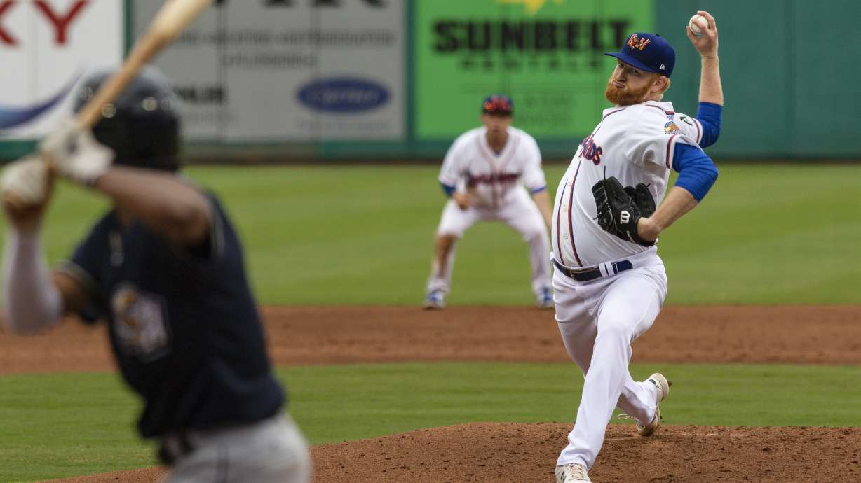 FILE - Midland RockHounds pitcher Brady Feigl throws during a Double-A baseball game against the San Antonio Missions on May 11, 2021, in Midland, Texas. Major League Baseball agreed to pay minor leaguers $185 million to settle a federal lawsuit alleging violations of minimum wage laws, a case that progressed through the courts for eight years without reaching a trial.