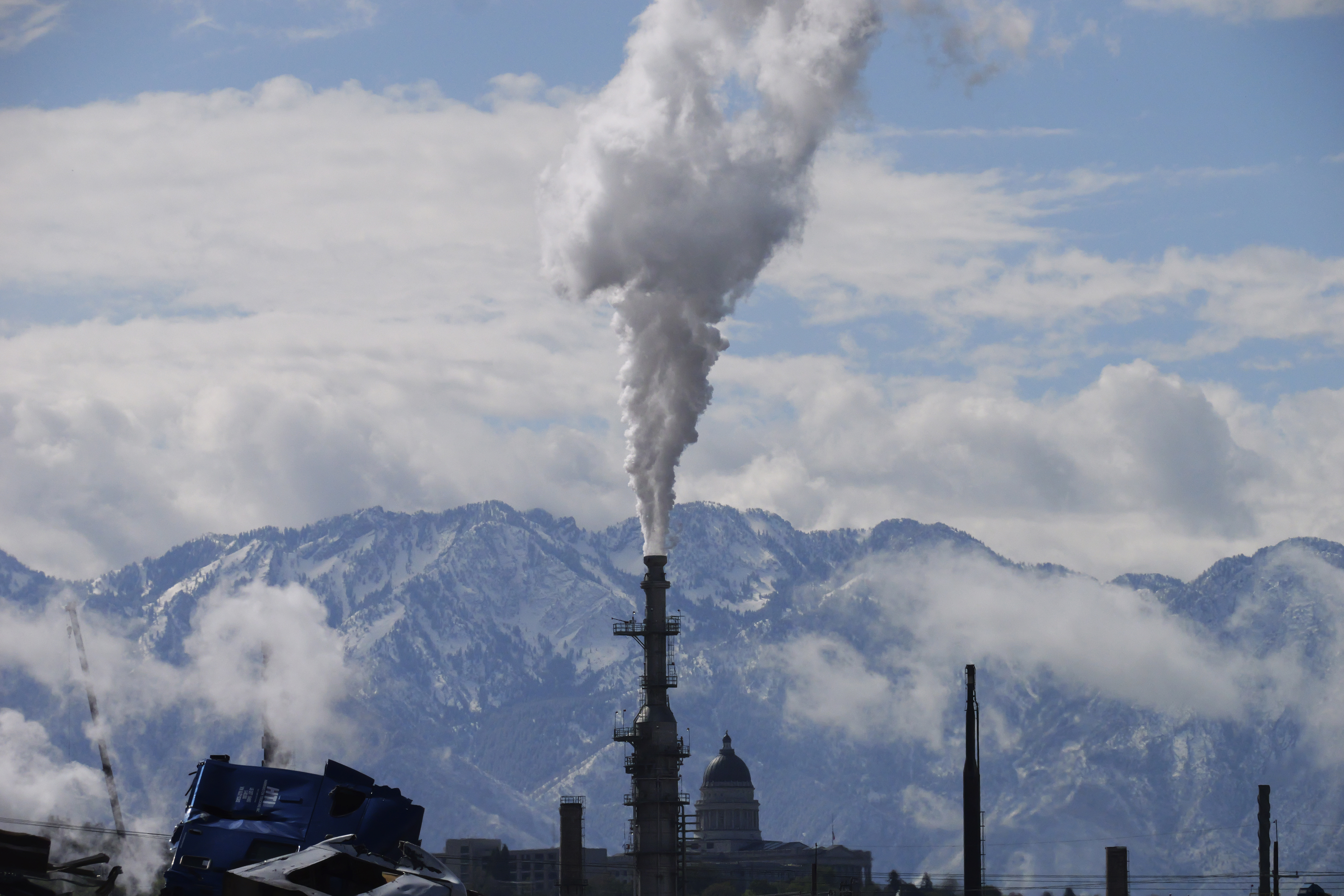 The Utah Capitol, rear, is shown behind an oil refinery on May 12 in Salt Lake City. President Joe Biden is promising “strong executive action” to combat climate change, despite dual setbacks that have restricted his ability to regulate carbon emissions and boost clean energy such as wind and solar power.