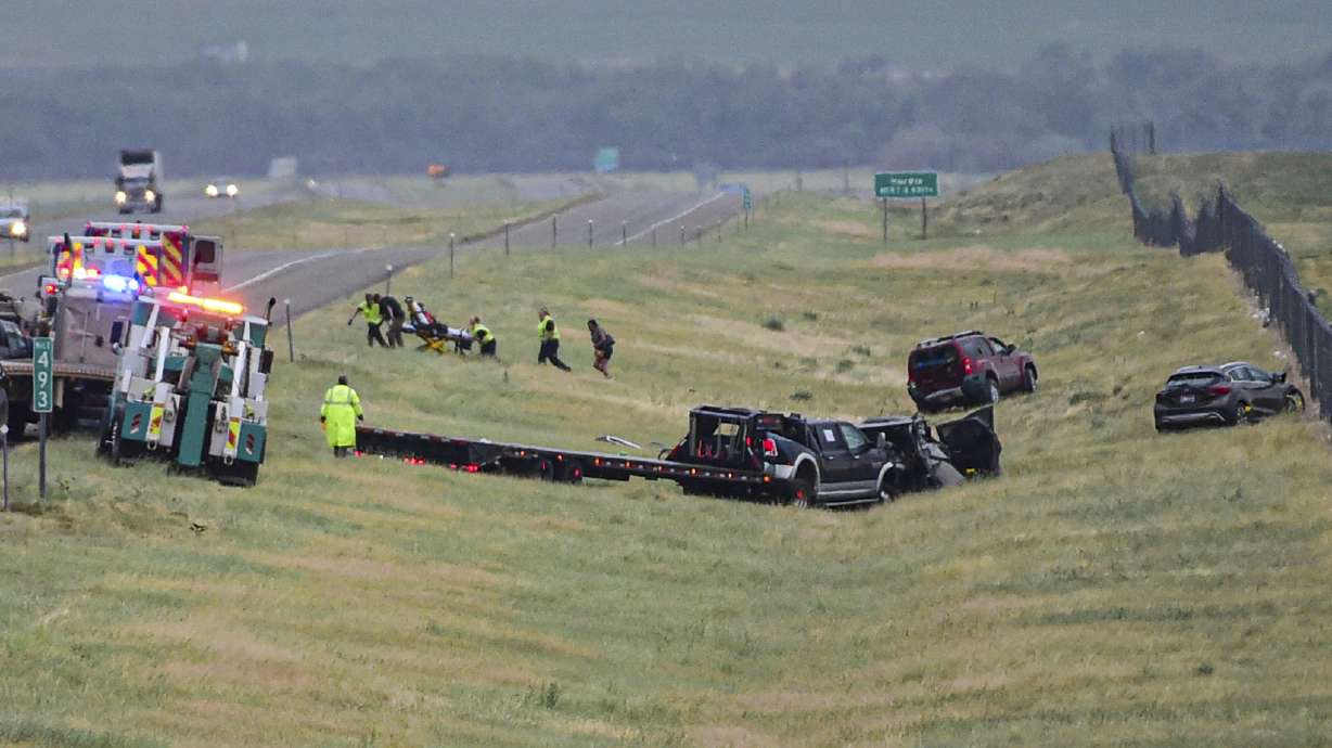 First responders work the scene on Interstate 90 after a fatal pileup where at least 20 vehicles crashed near Hardin, Mont., Friday.