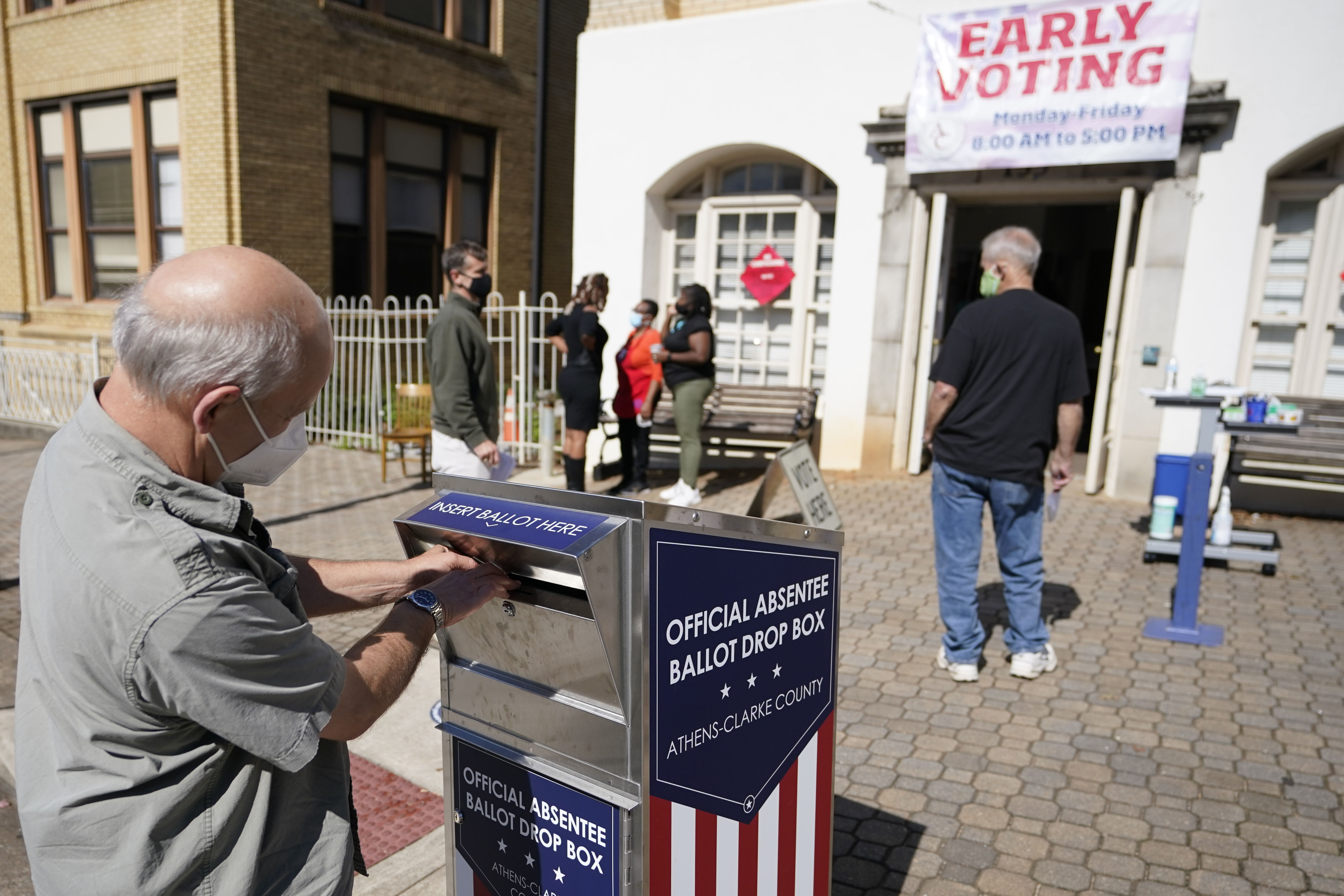A voter submits a ballot in an official drop box during early voting in Athens, Ga., on Oct. 19, 2020. The widespread use of absentee ballot drop boxes during the 2020 election was largely trouble-free, contrary to claims made by former President Donald Trump and his Republican allies. An Associated Press survey of state election officials across the U.S. revealed no problems that could have affected the results, including from fraud, vandalism or theft.