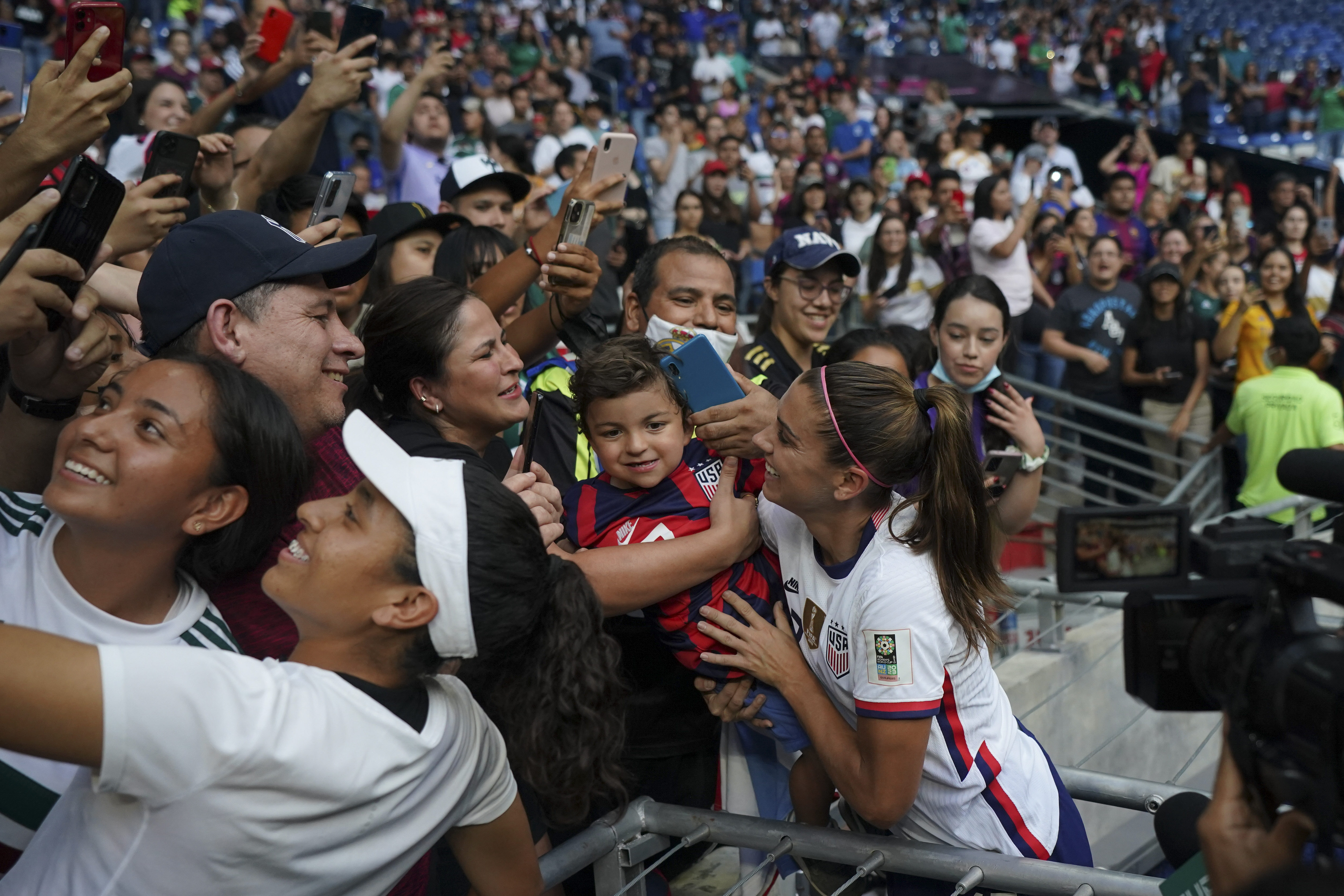 United States' Alex Morgan holds a child as she greats fans after defeating Jamaica 5-0 in a CONCACAF Women's Championship soccer match in Monterrey, Mexico, Thursday, July 7, 2022. 