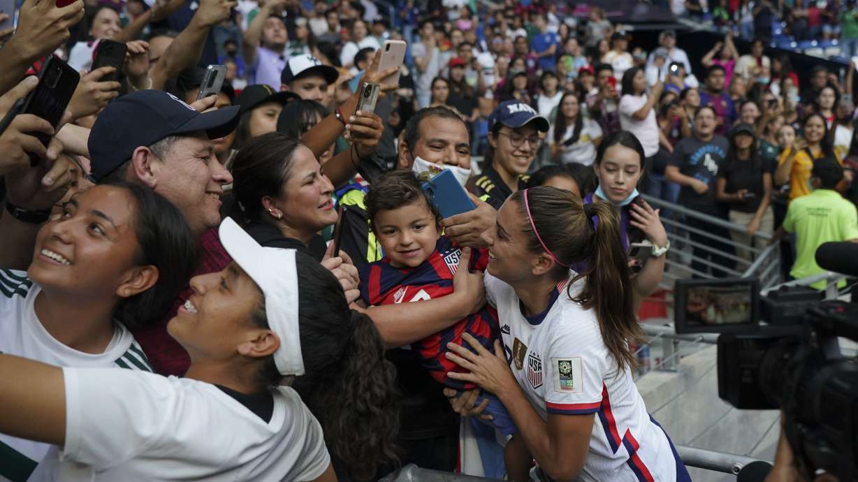 United States' Alex Morgan holds a child as she greats fans after defeating Jamaica 5-0 in a CONCACAF Women's Championship soccer match in Monterrey, Mexico, Thursday, July 7, 2022.