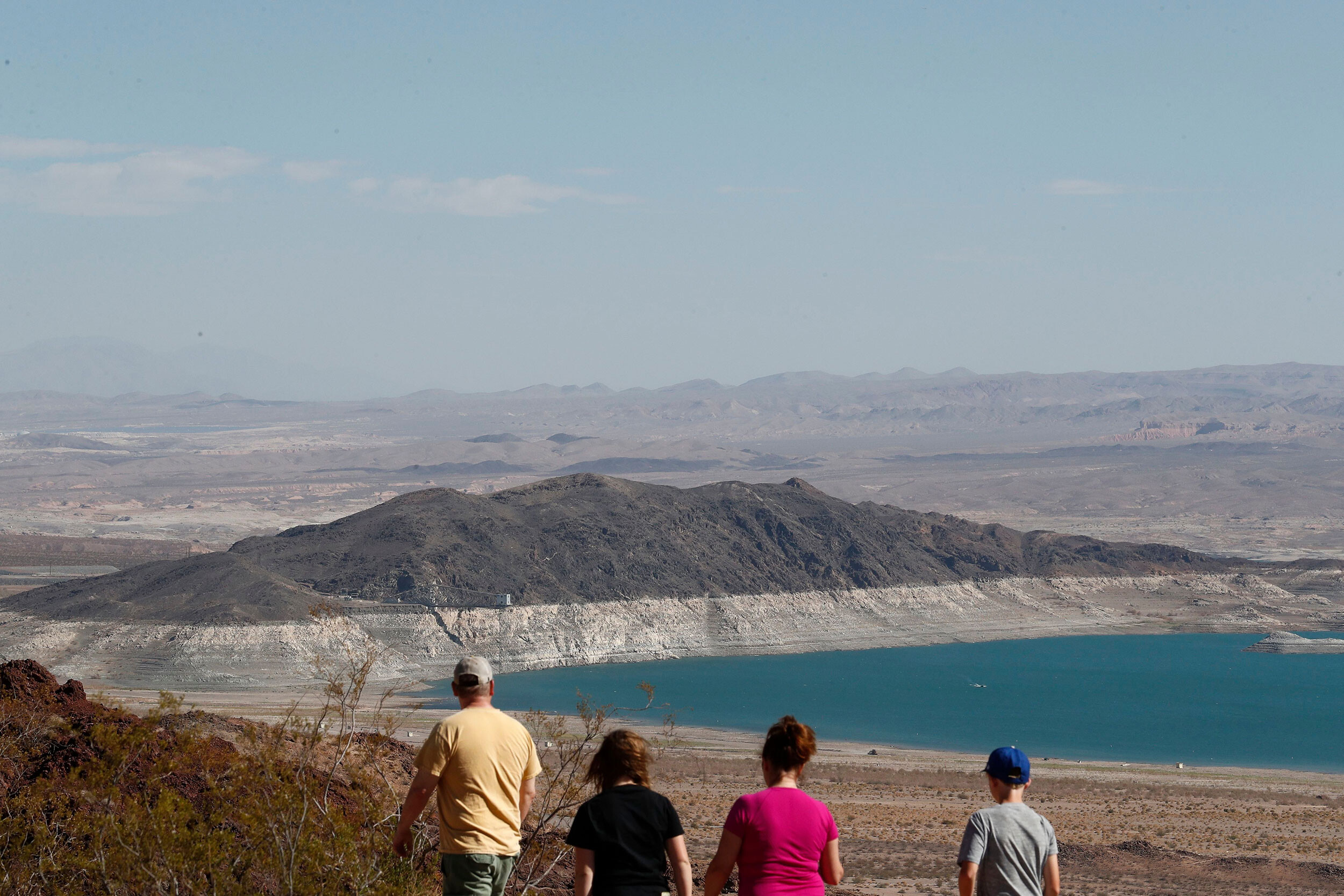 People look out at Lake Mead from the Overlook at Hoover Dam Lodge in Boulder City, Nevada, on June 30. More extreme water cuts are all but certain in the Southwest starting next year, according to the latest government forecast for the Colorado River and Lake Mead, the country's largest reservoir.