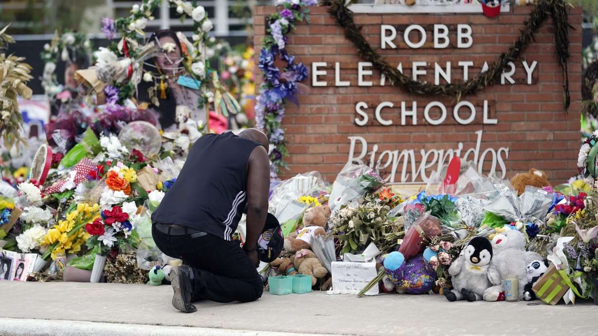 Reggie Daniels pays his respects at a memorial at Robb Elementary School on June 9, in Uvalde, Texas. The gunman who killed 19 children and two teachers at an elementary school in Uvalde, Texas, left so many hints that he was violent and obsessed with notoriety that former classmates began calling him "school shooter."
