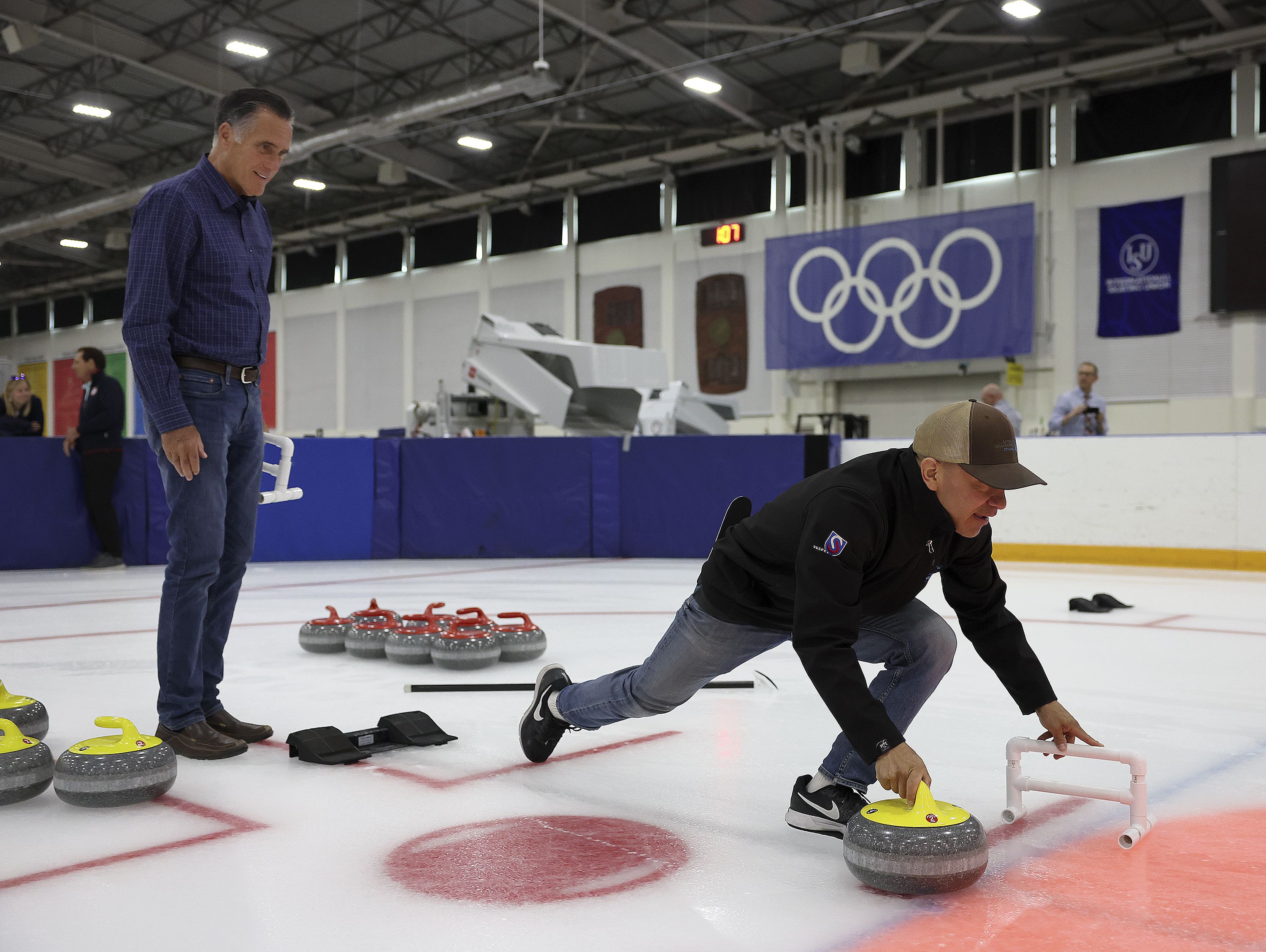 Derek Parra, inline skater and speedskater who won two medals at the 2002 Winter Olympics, shows Sen. Mitt Romney, R-Utah, how to curl at the Utah Olympic Oval in Kearns on Friday, May 27.